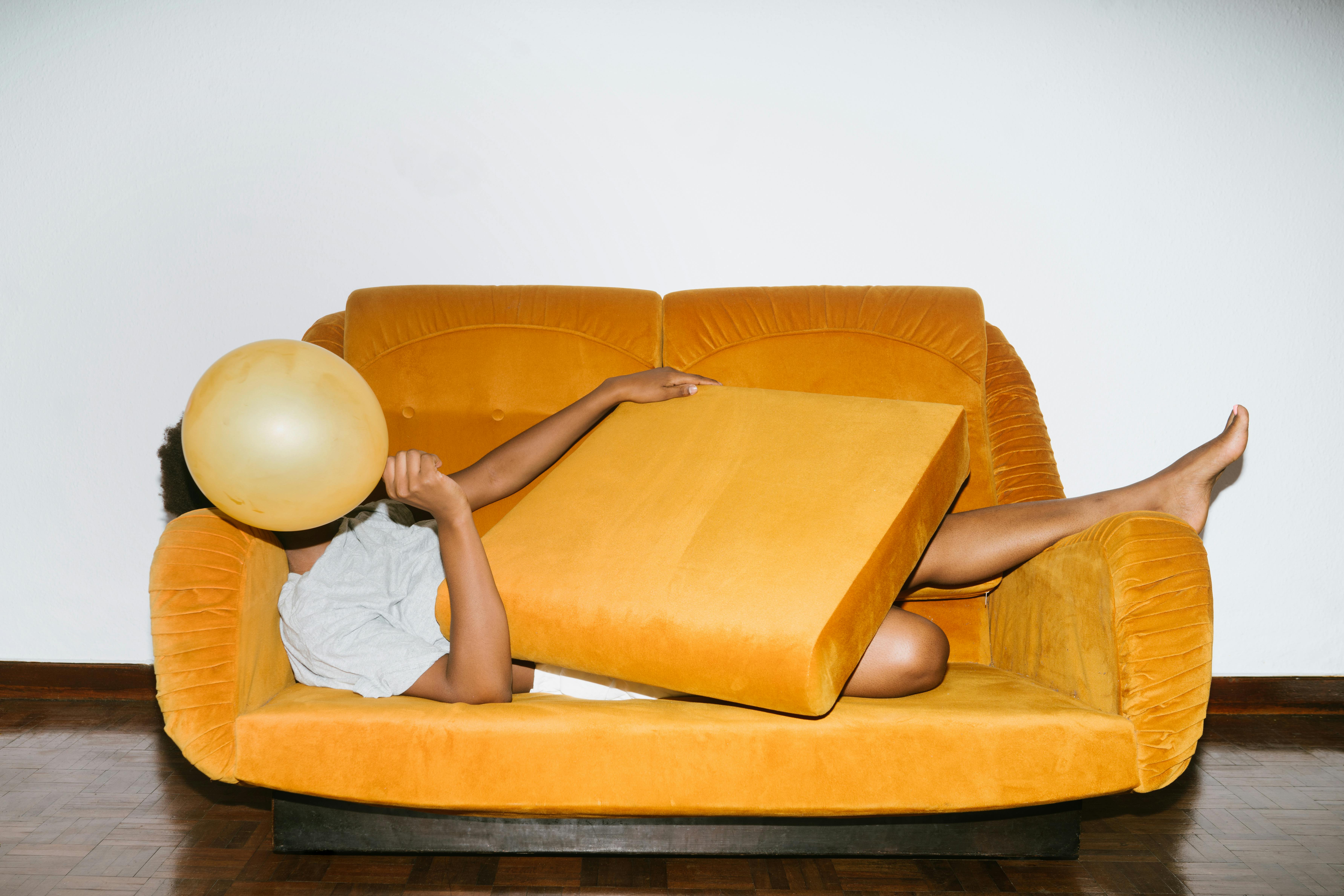 person lying on orange sofa