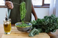 木桌上放着新鲜的青羽衣甘蓝面，配以橄榄油，非常适合健康膳食