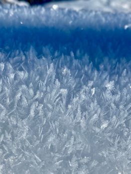 Detailed view of ice crystals in a frosty outdoor setting. Captures the winter texture.