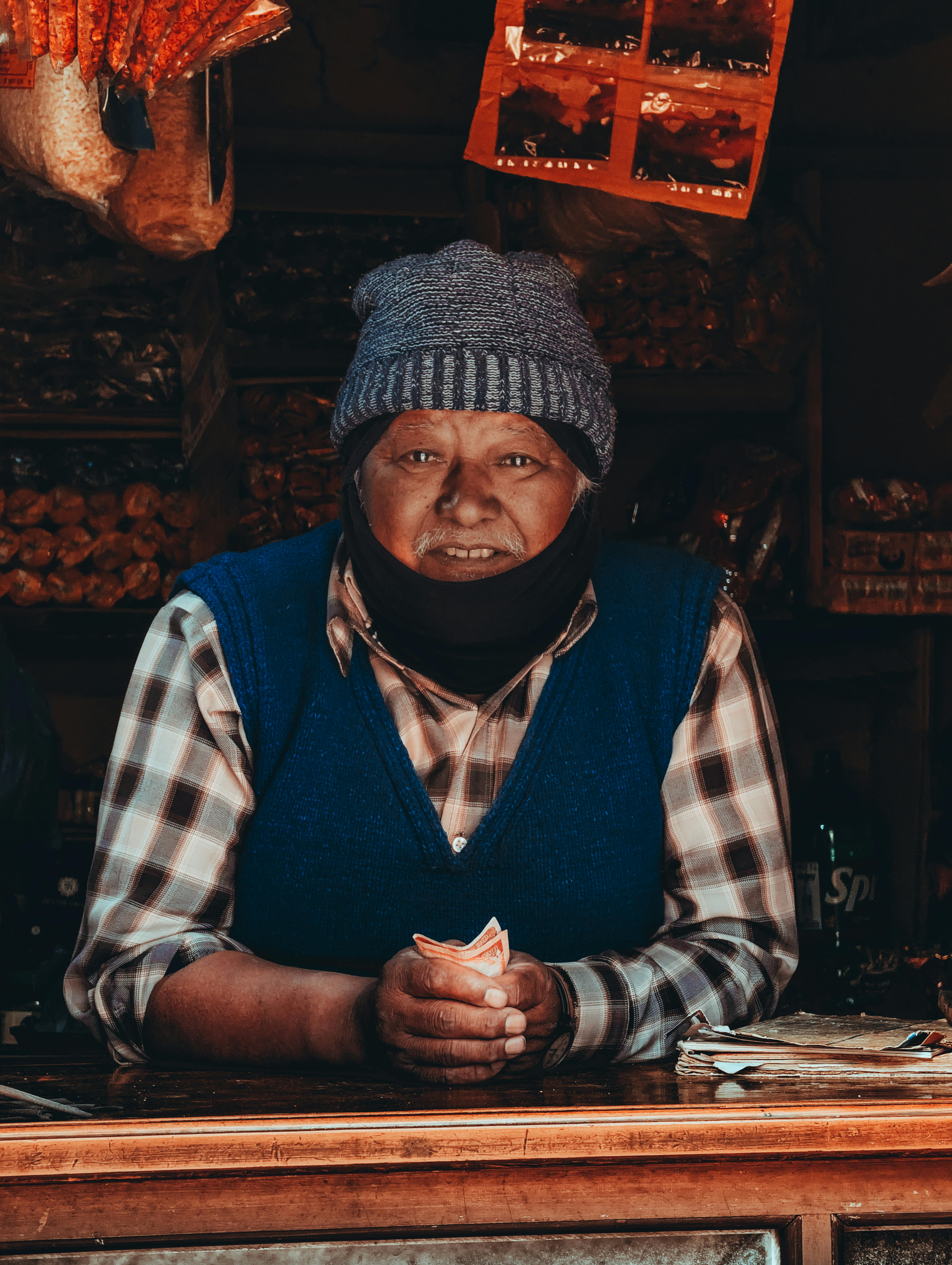 Gratis Ældre butiksindehaver i Chitlang, Nepal, iført hat i hyggelige butikslokaler. Lagerfoto