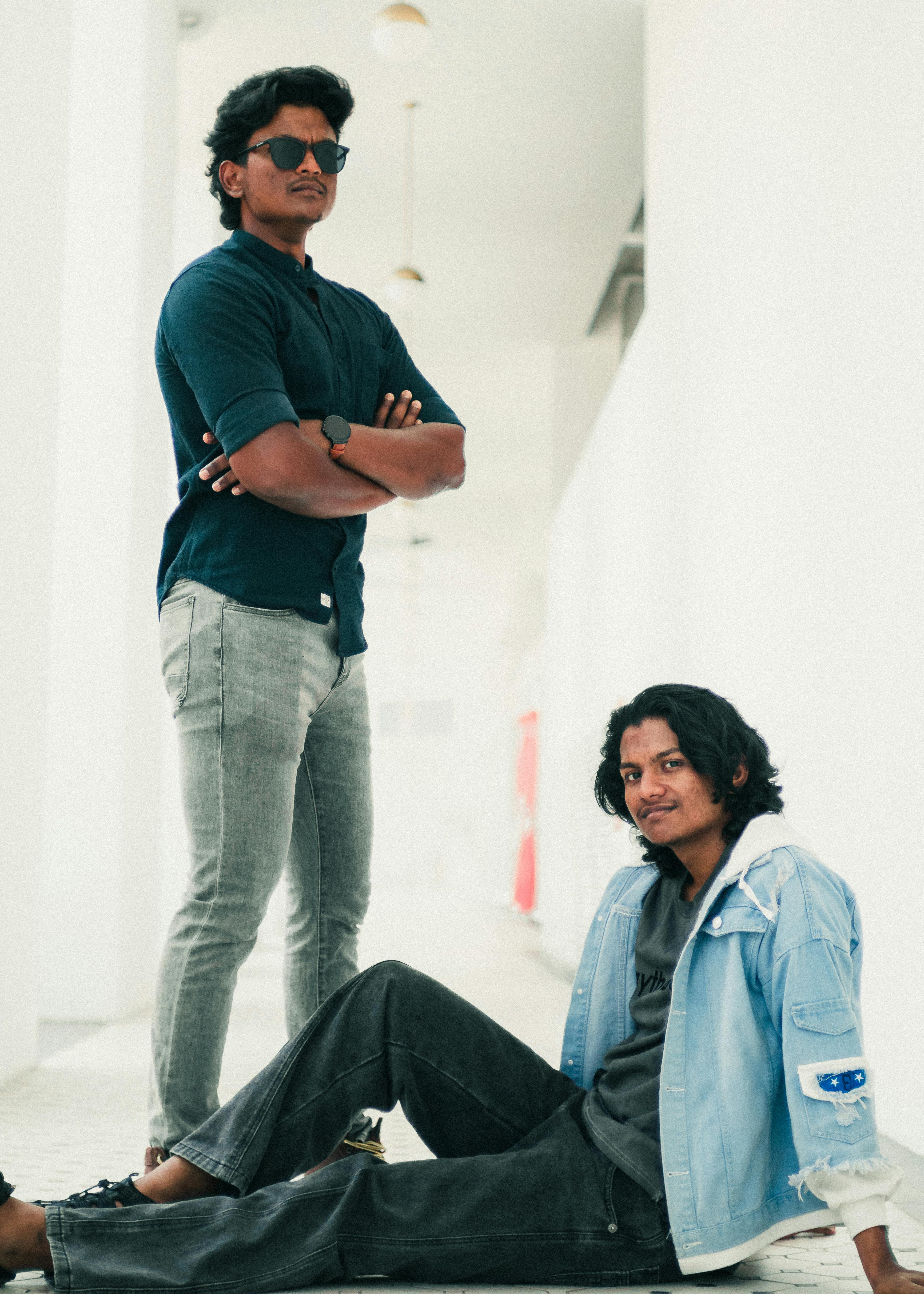 Ilmainen Kaksi tyylikästä nuorta miestä poseeraa itsevarmasti modernissa käytävällä George Townissa, Malesiassa. Kuvapankkikuva