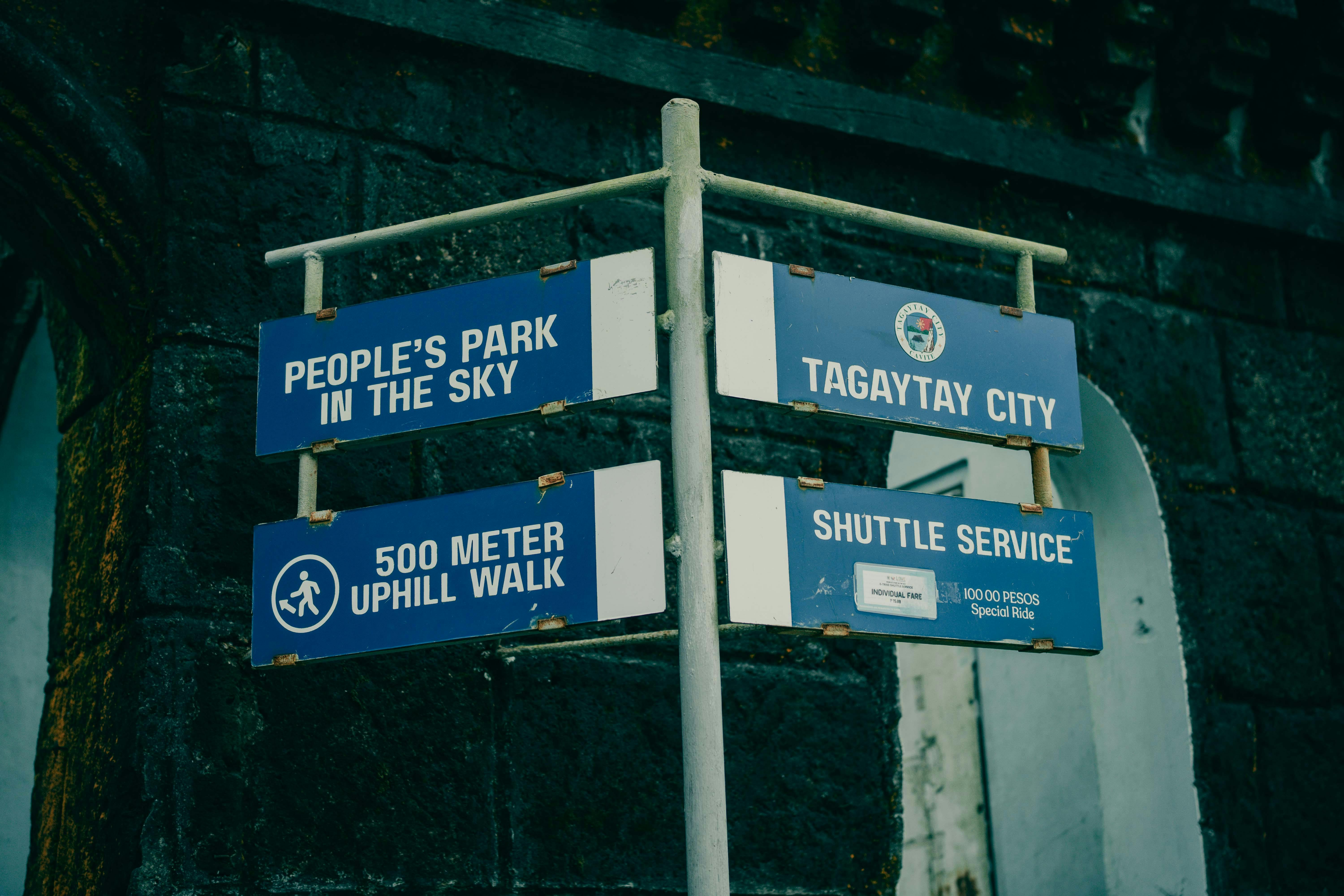 Free Blue directional signs for People's Park in Tagaytay City, Philippines, with shuttle service details. Stock Photo