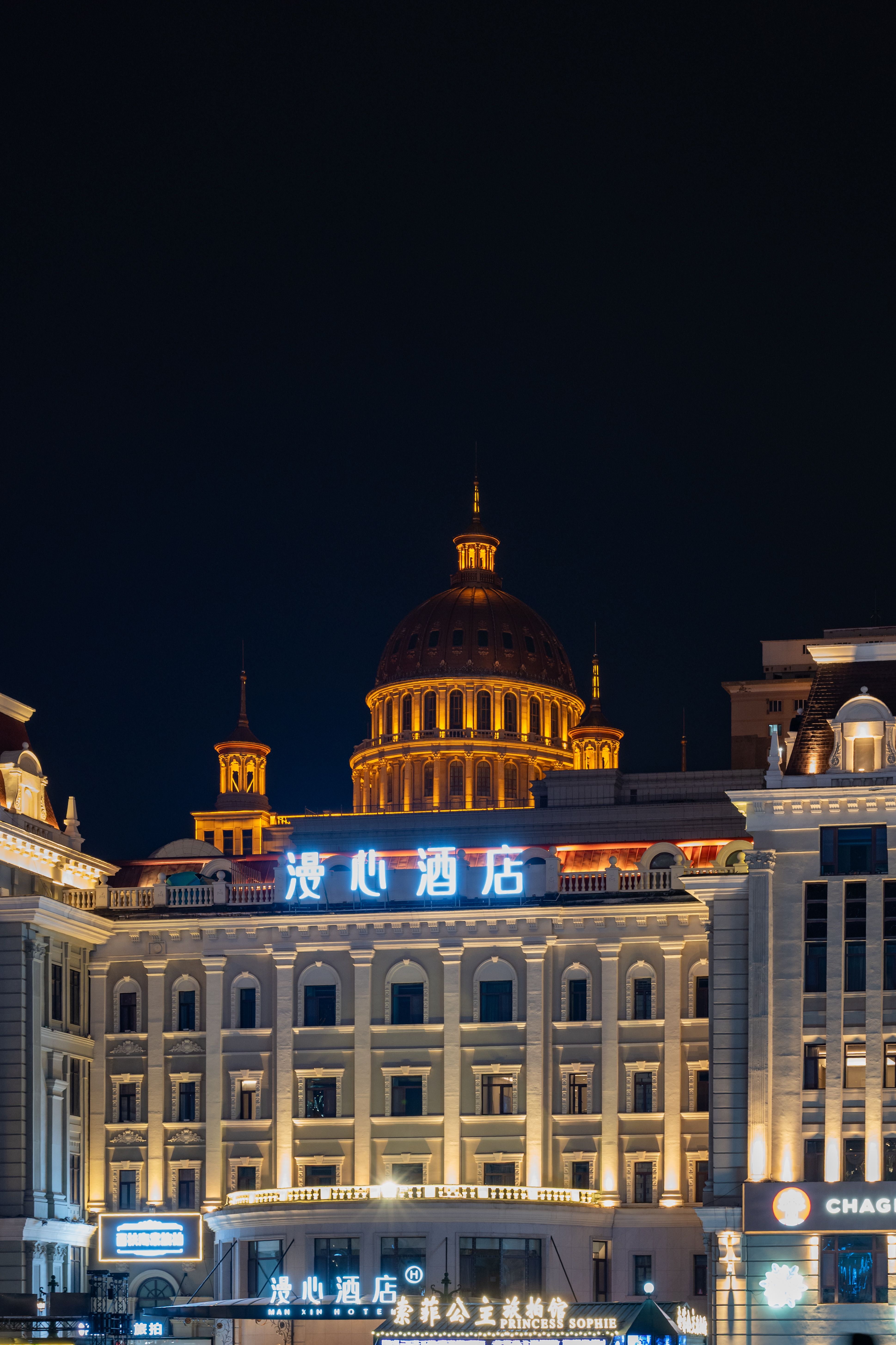 Illuminated building on Central Street in Harbin, China, showcasing classical architecture at night.