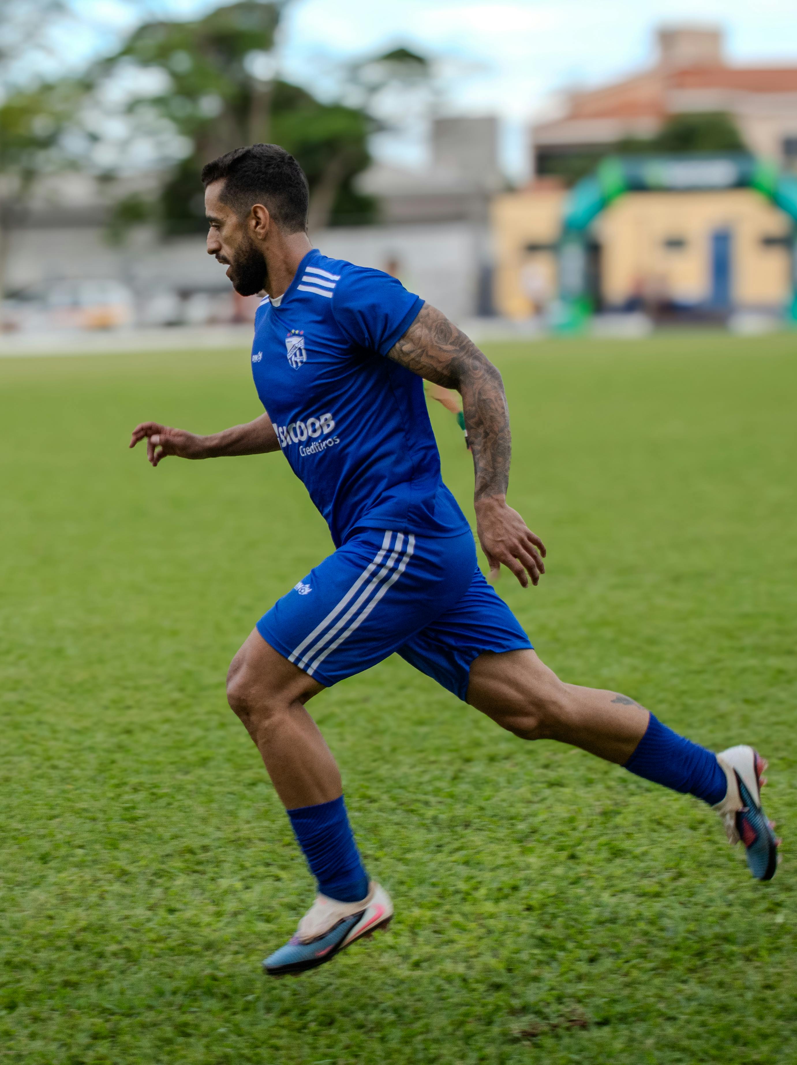 Athlete in motion on a grassy soccer pitch, showcasing intense focus and athleticism.