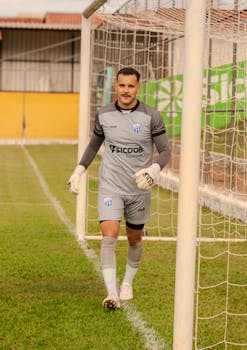 Goalkeeper in action on the soccer field during practice under a sunny sky.