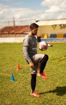 Professional football player practicing drills on a sunny day outdoors.