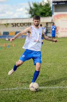 Soccer player practicing on grass field, training session outdoors.