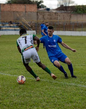 Players from opposing teams compete in a dynamic soccer match on a grassy field.