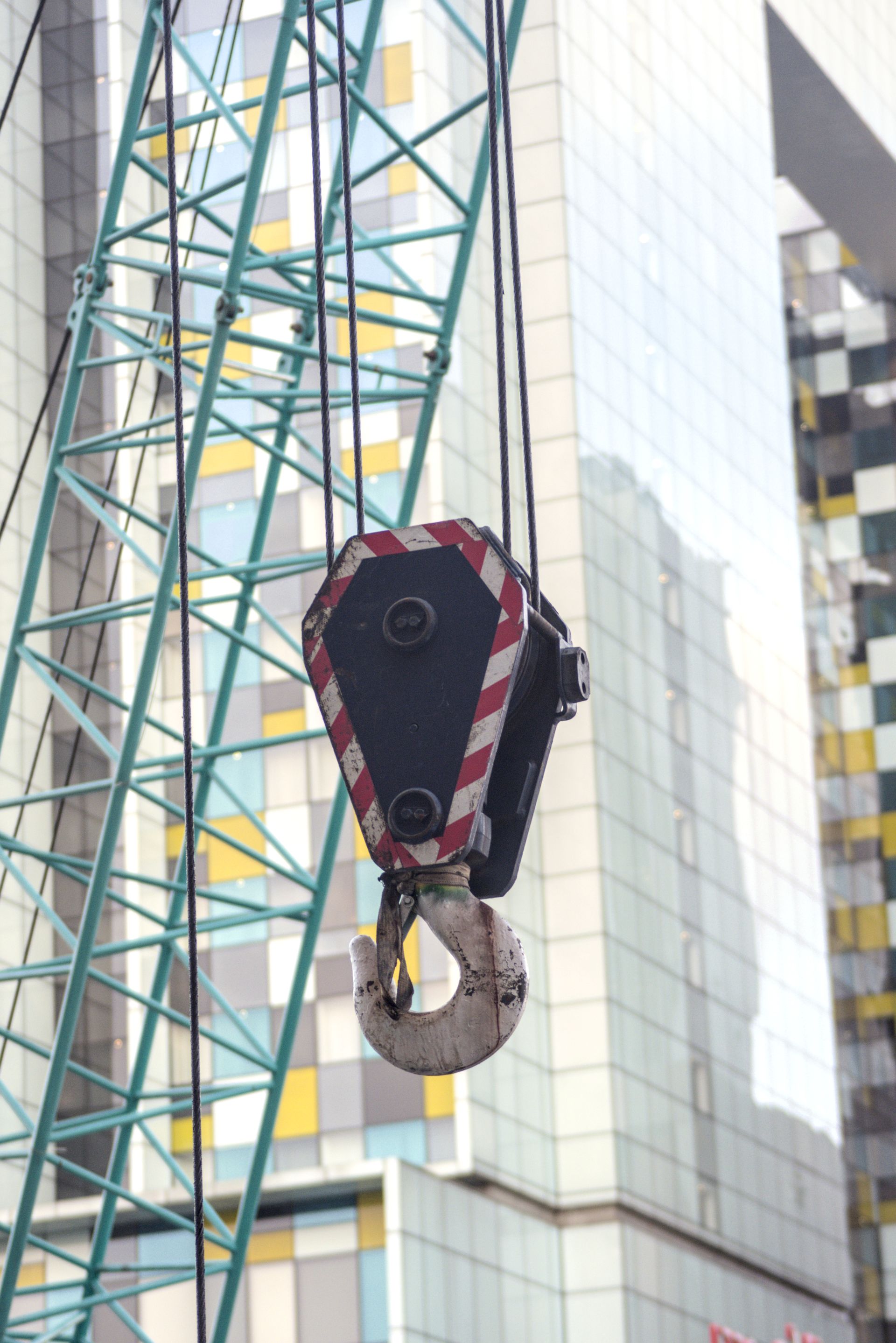 Close-up of a tower crane's hook at an urban construction site