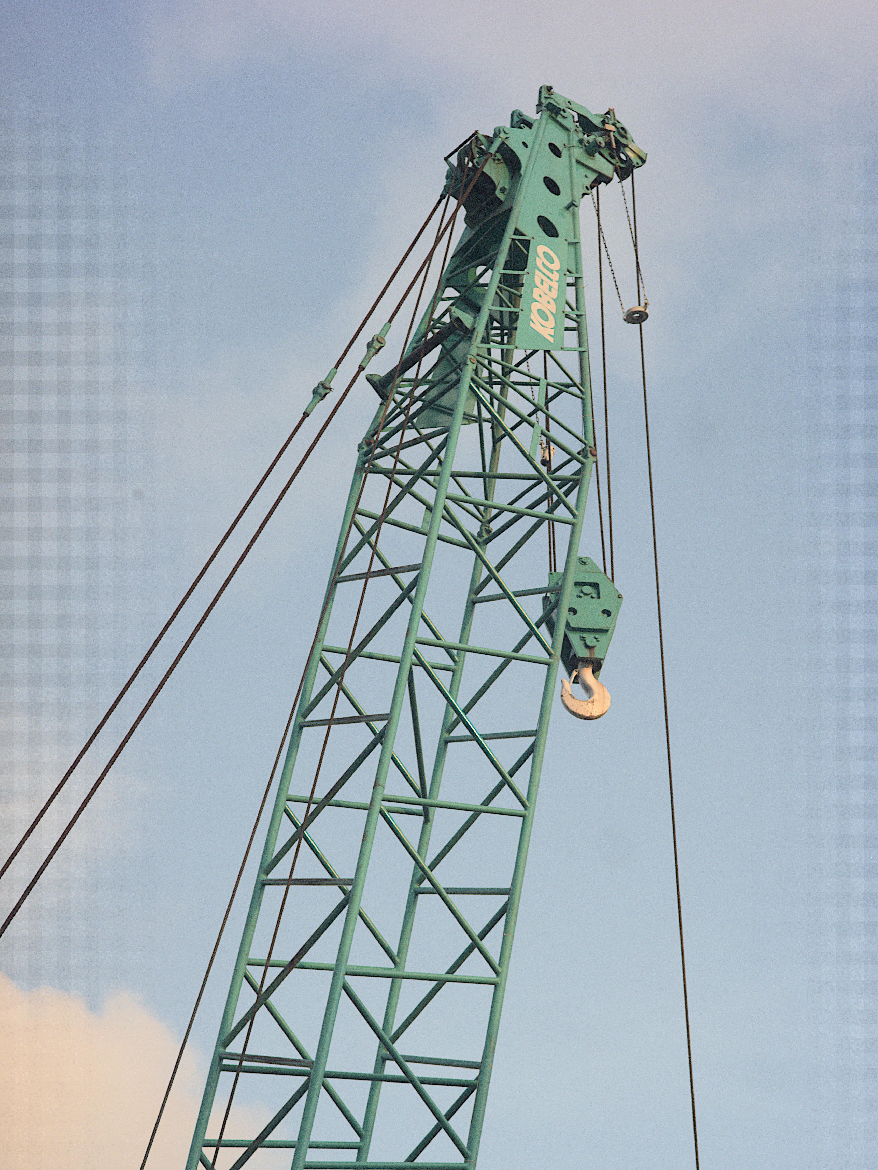 Ilmainen Korkea teollisuusnosturi, jossa on ristikkorakenne kirkasta sinistä taivasta vasten, ihanteellinen rakennusteemoihin. Kuvapankkikuva