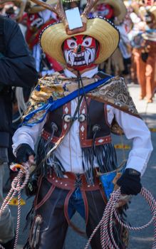 Vibrant masked performer in traditional attire at Pachuca festival, capturing Mexican cultural heritage.