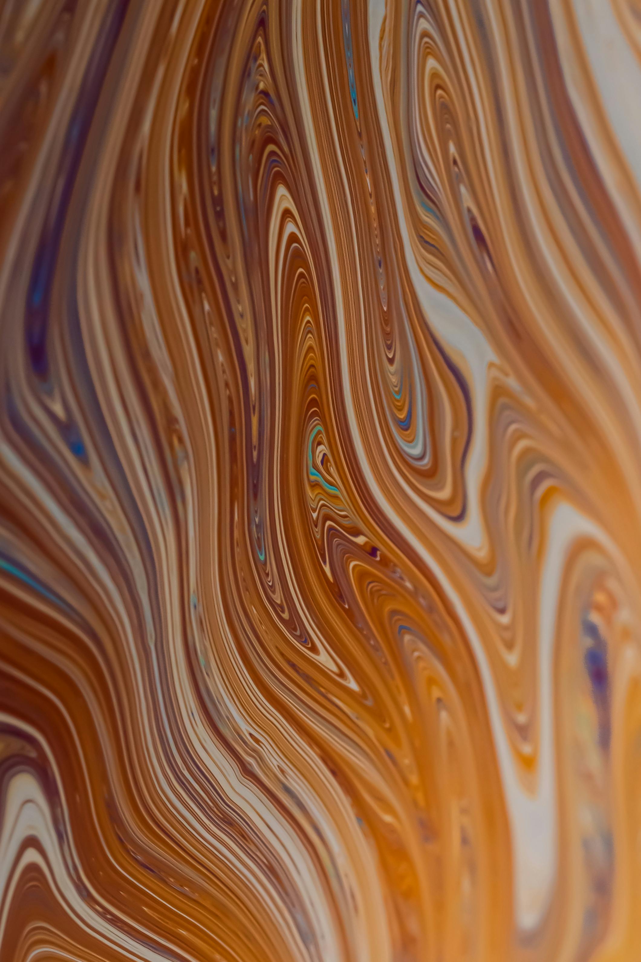 Bezpłatne Abstrakcyjny obraz z wirującymi pomarańczowymi i brązowymi wzorami, przypominający sztukę płynną. Zdjęcie z galerii