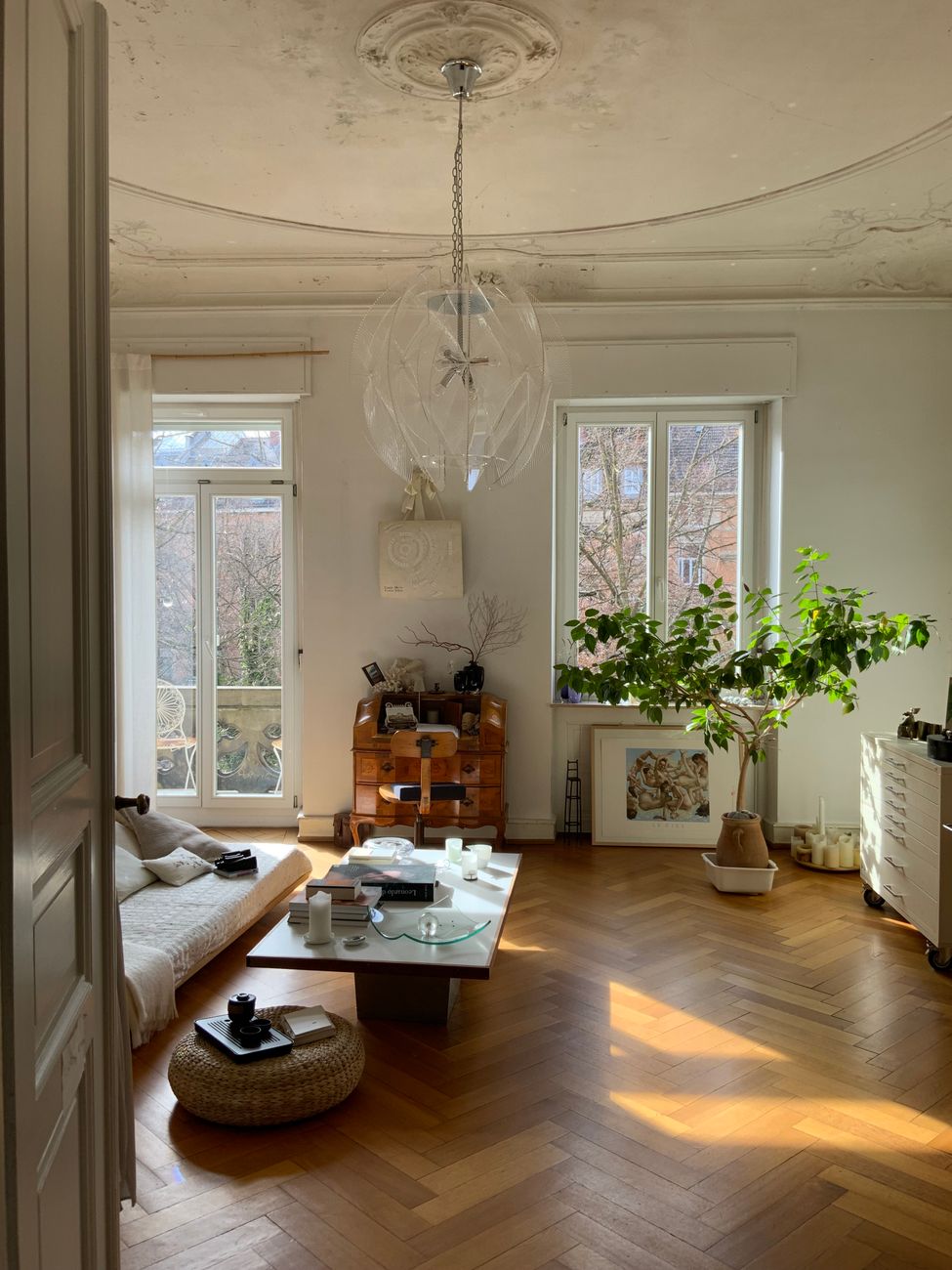 Stylish living room featuring modern furniture, sunlight, and indoor greenery for a warm, inviting atmosphere.