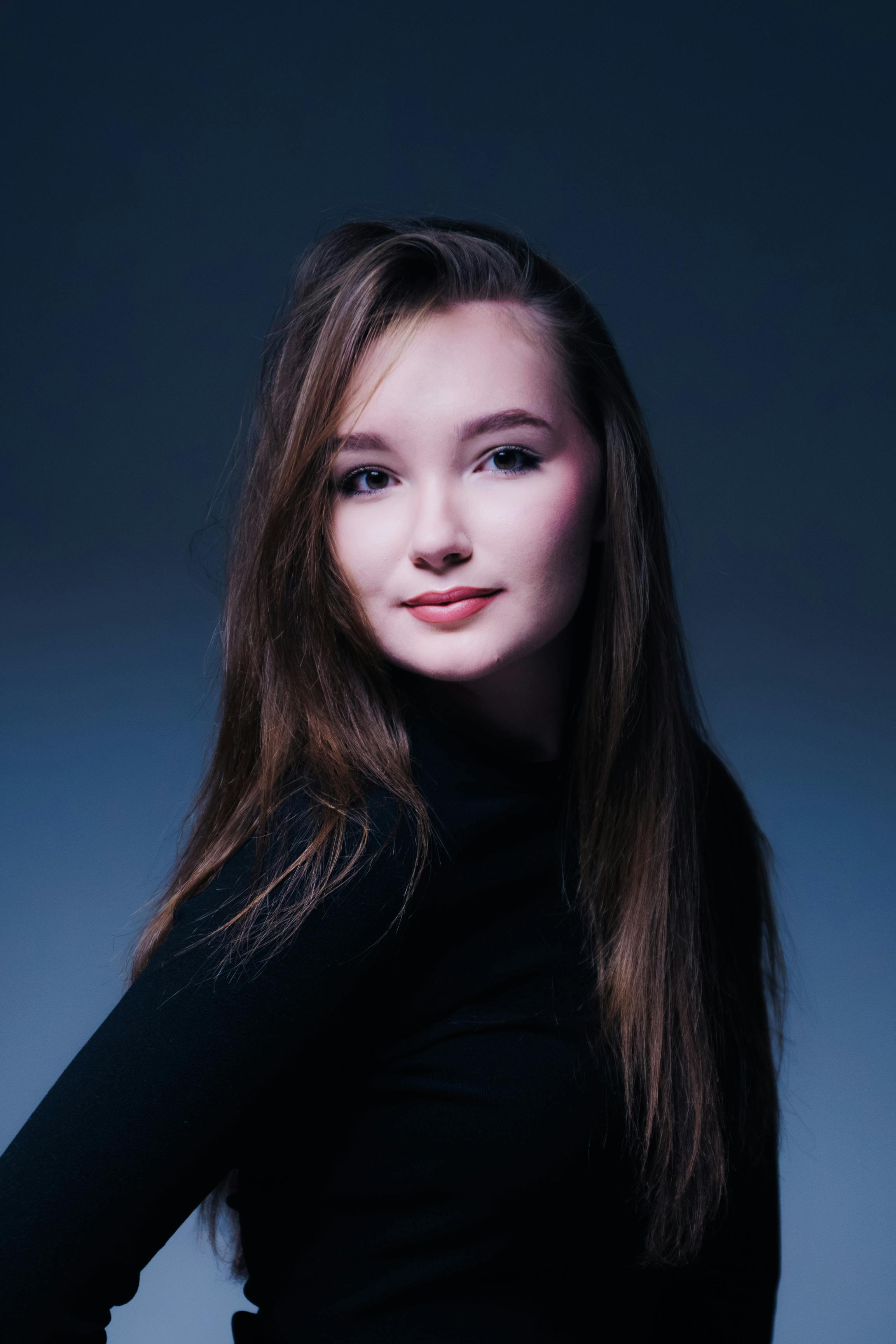 Ücretsiz Şık saç stili ve kendinden emin ifadesiyle genç bir kadının sofistike stüdyo portresi. Stok Fotoğraflar