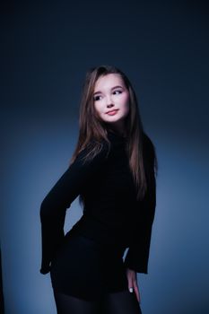 Striking portrait of a young woman in a black outfit with a confident pose.