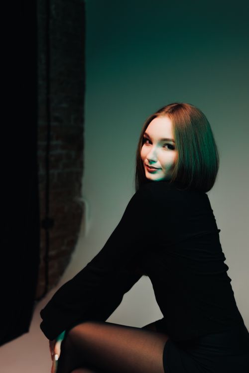 Free Chic portrait of a young woman in a modern setting, exuding elegance with her poised demeanor. Stock Photo