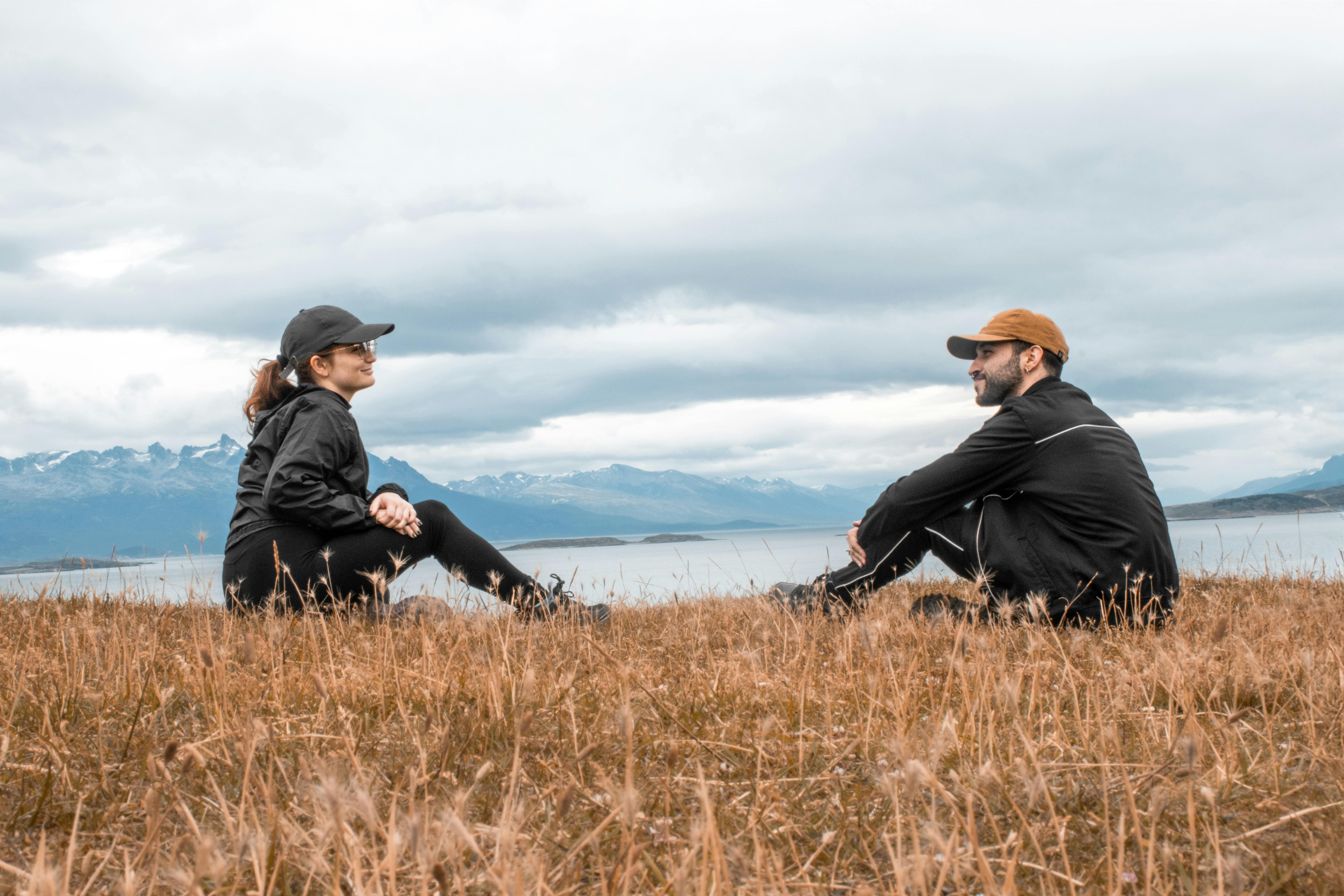 Bezpłatne Romantyczna para siedzi na zewnątrz w Ushuaia, w Argentynie, z zapierającym dech w piersiach widokiem na góry. Zdjęcie z galerii