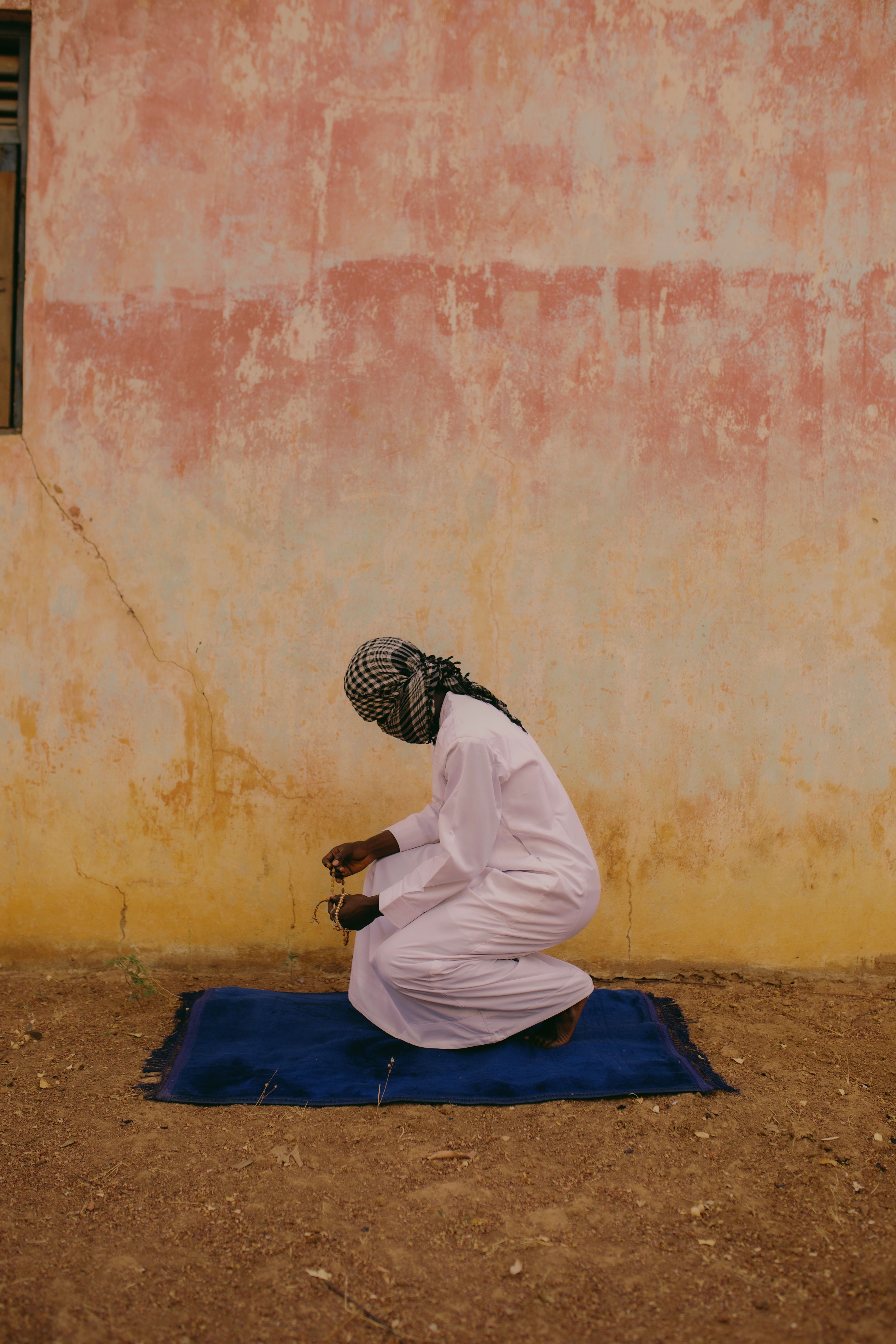 Man in Traditional Attire Praying Outdoors · Free Stock Photo