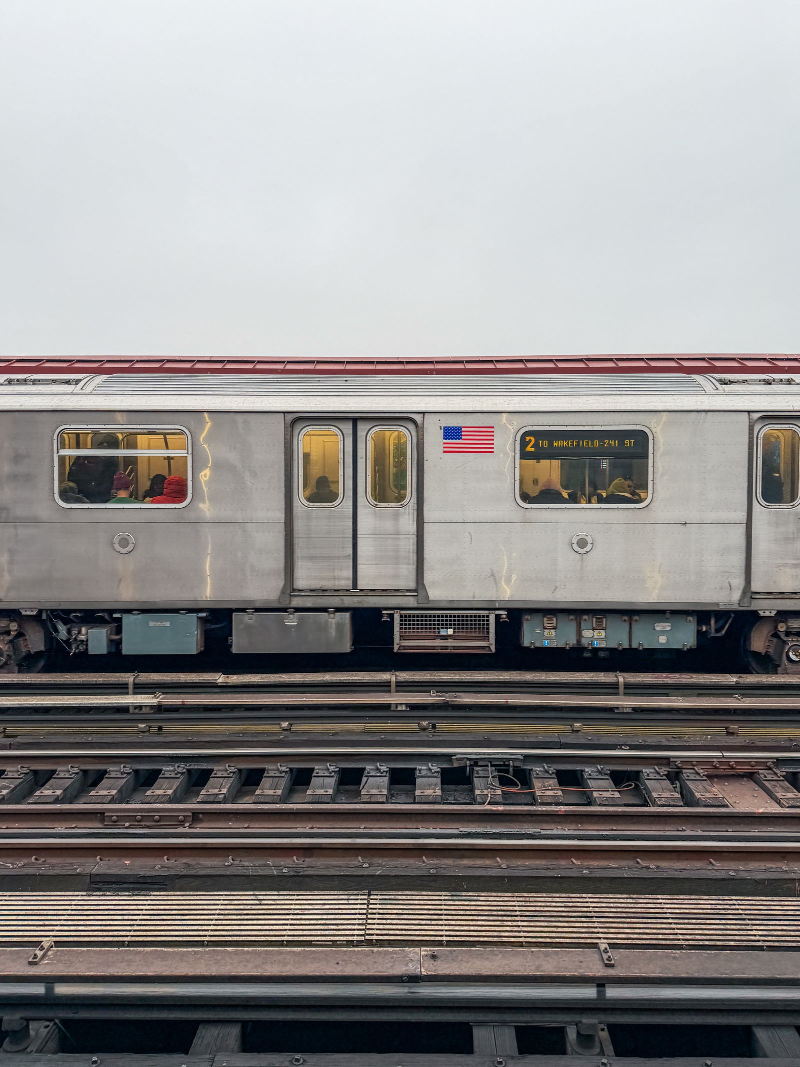Elevated airport train track with a train approaching a station platform