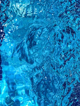 蓝色游泳池水的彩色特写，涟漪荡漾，倒影清晰