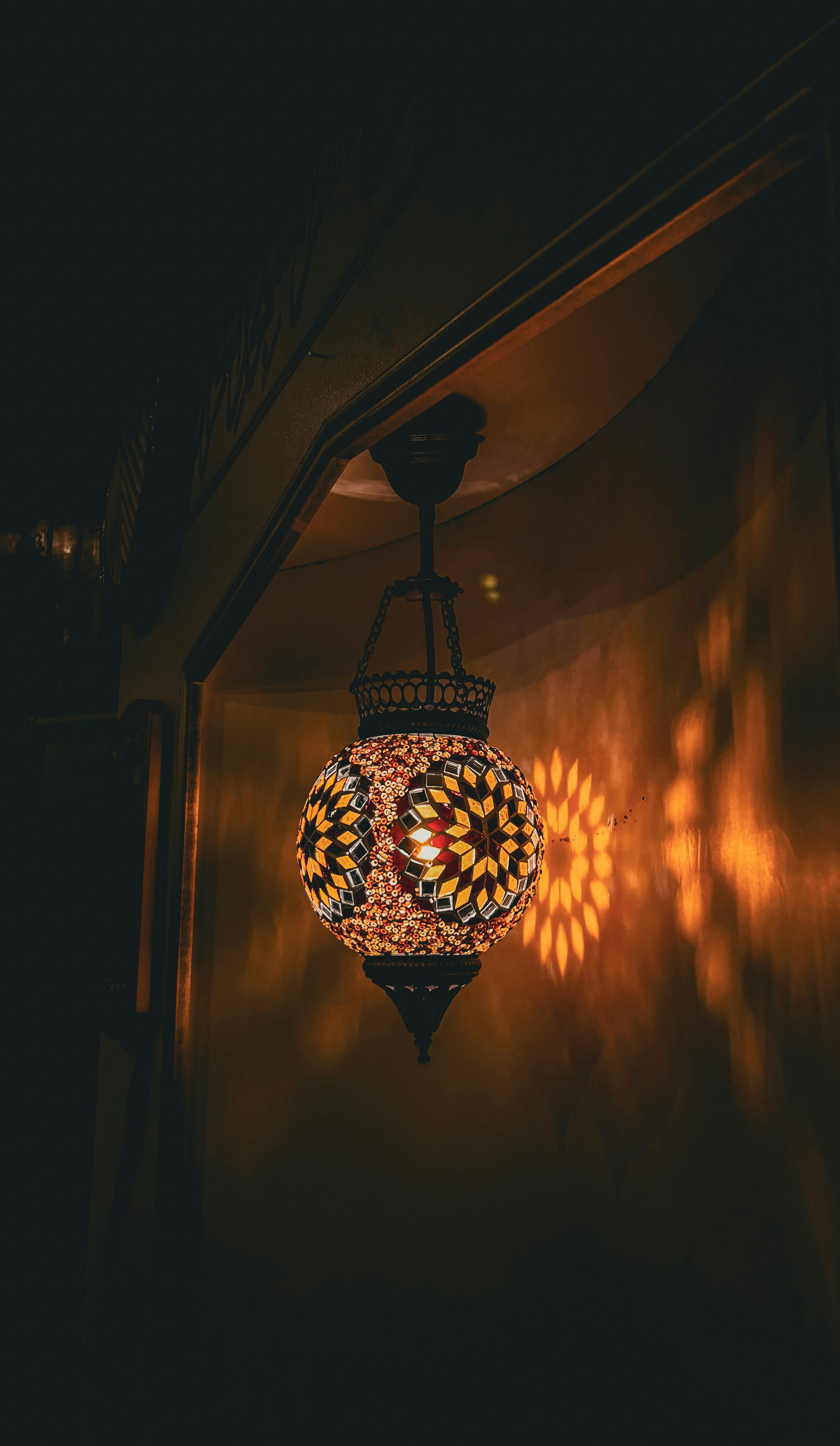 Gratis En varmt opplyst mosaikklampe kaster intrikate skygger på veggen og skaper en koselig atmosfære. Arkivbilde