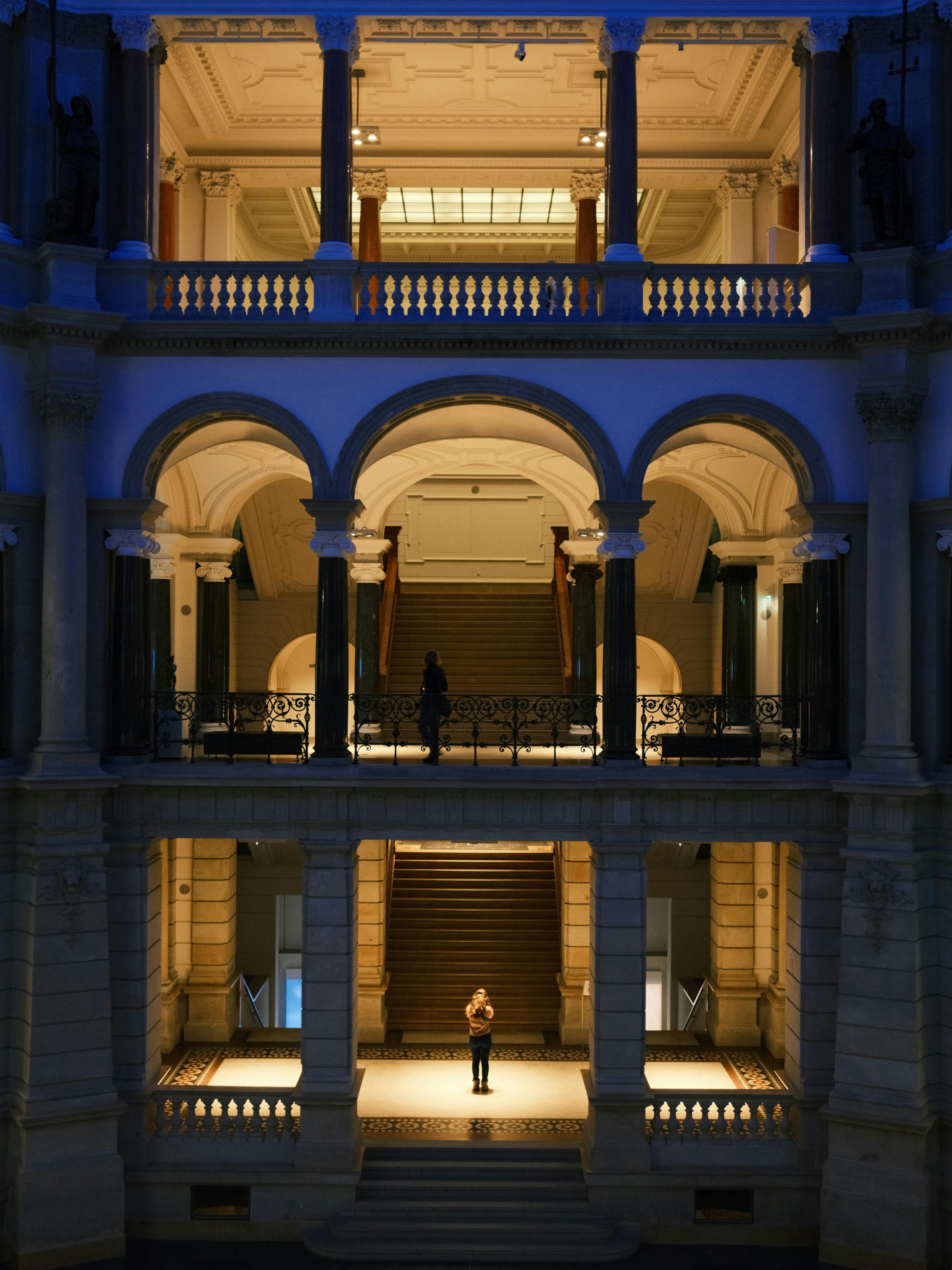 Gratis Udforsk den storslåede arkitektur og den stemningsfulde belysning i en Berliner museums lobby om natten. Lagerfoto