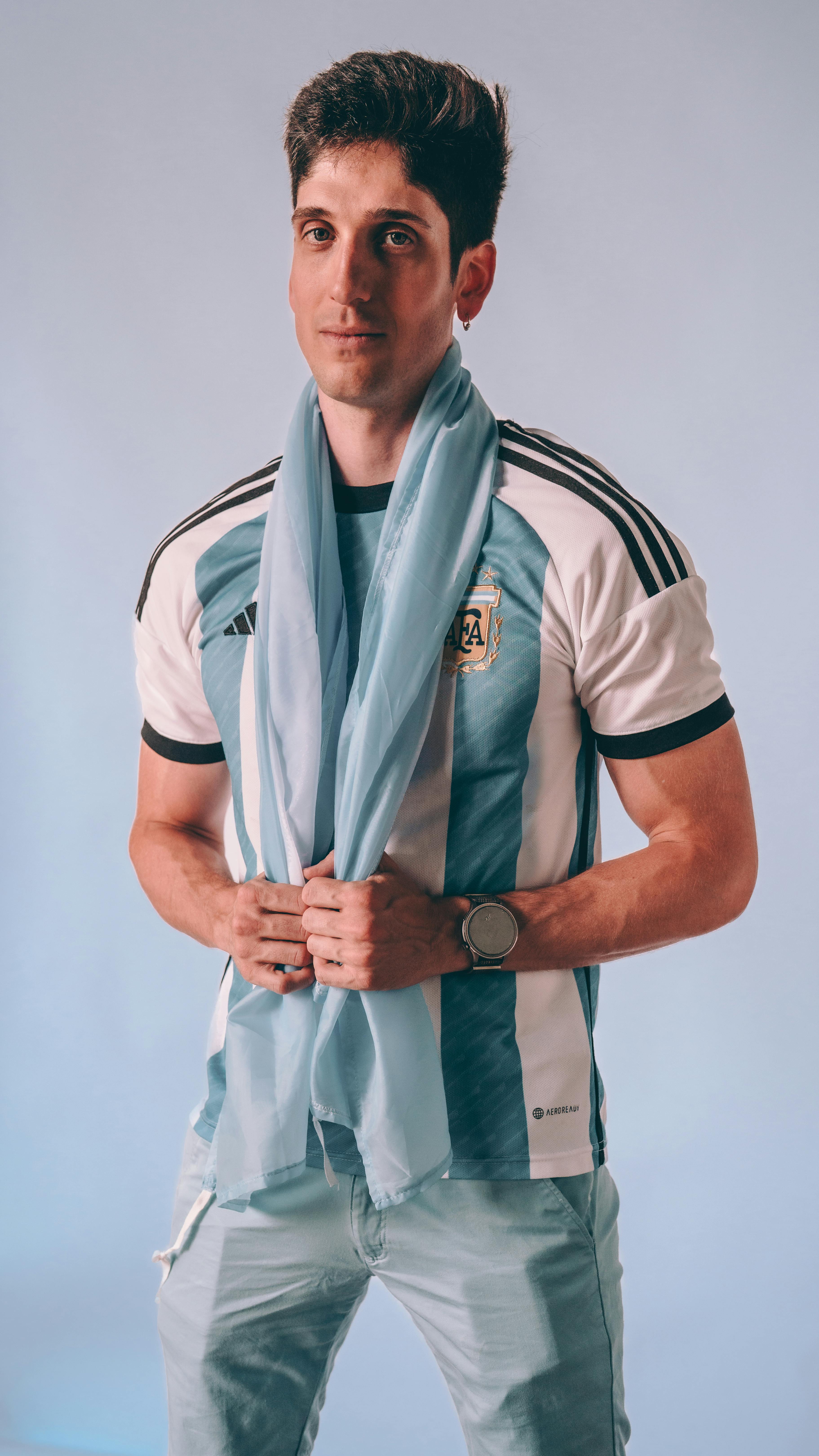 무료 파란색 배경에 아르헨티나 축구 유니폼과 스카프를 착용한 남자. 스톡 사진