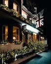 伦敦酒店正面装饰着英国国旗和节日彩灯，夜色中营造出迷人的氛围