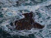 Aerial View of Waves Crashing on Sea Rock