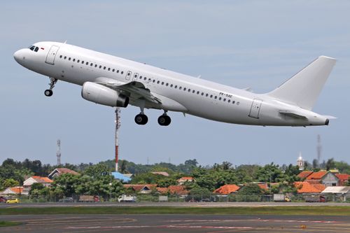 Free A commercial airplane taking off from an airport runway, showcasing aviation dynamics. Stock Photo