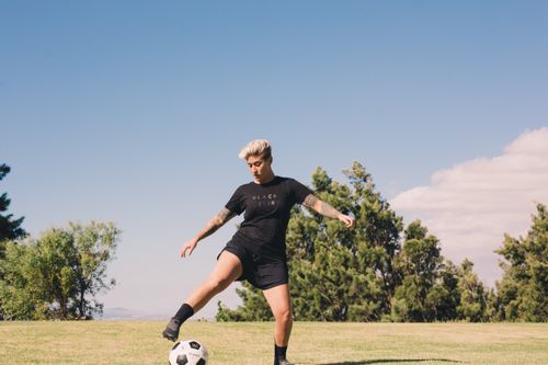 Jogador De Futebol Chutando Bola De Futebol Cinza Branco No Campo De jogador-de-futebol-chutando-bola-de-futebol-cinza-branco-no-campo-de