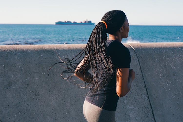 Photo Of Woman Running Near Sea Wall