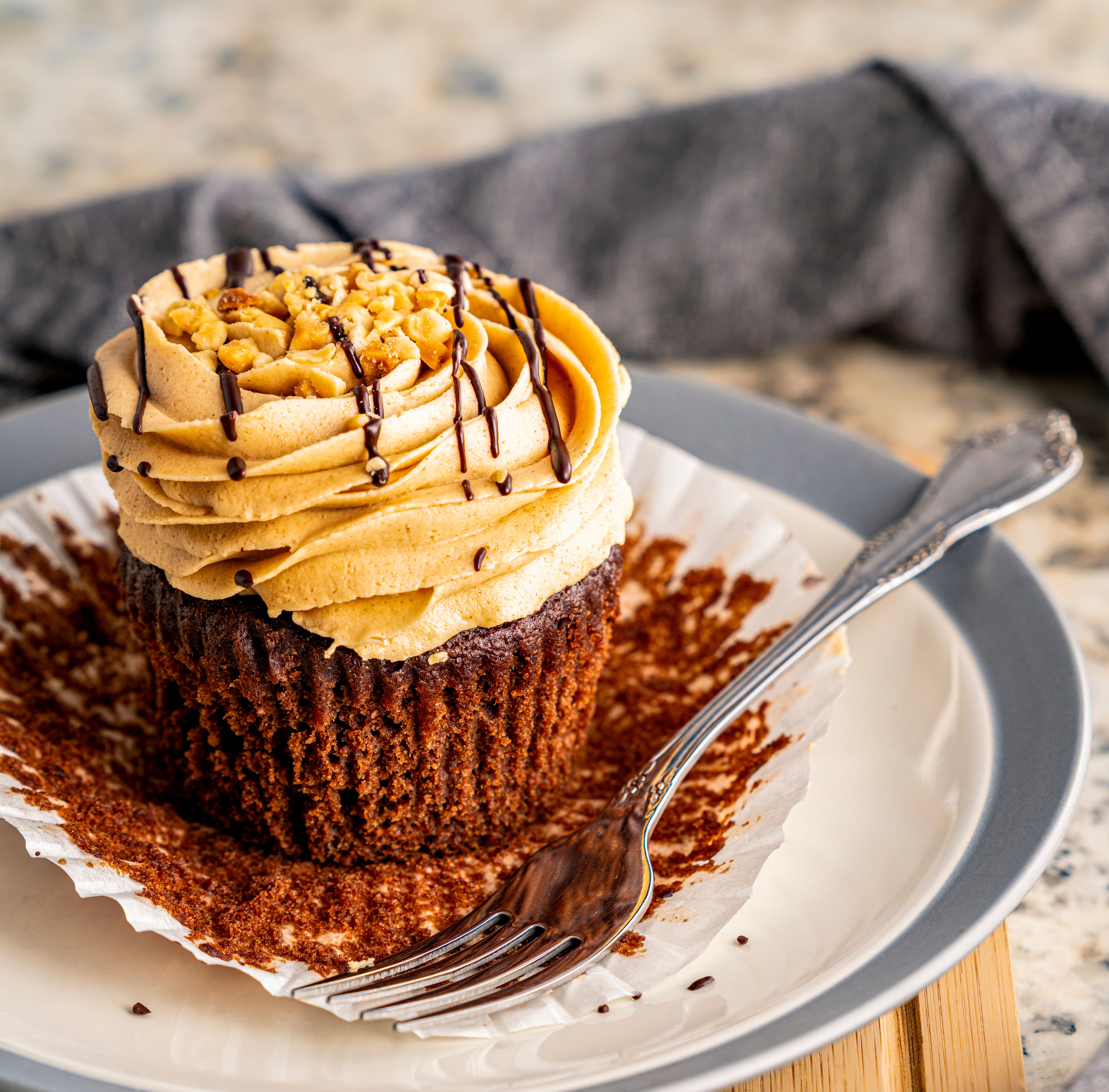 Mouthwatering chocolate cupcake with creamy frosting and chocolate drizzle, ready to be enjoyed.