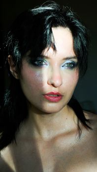 Close-up portrait of a woman with dramatic eye makeup, capturing intensity and elegance.
