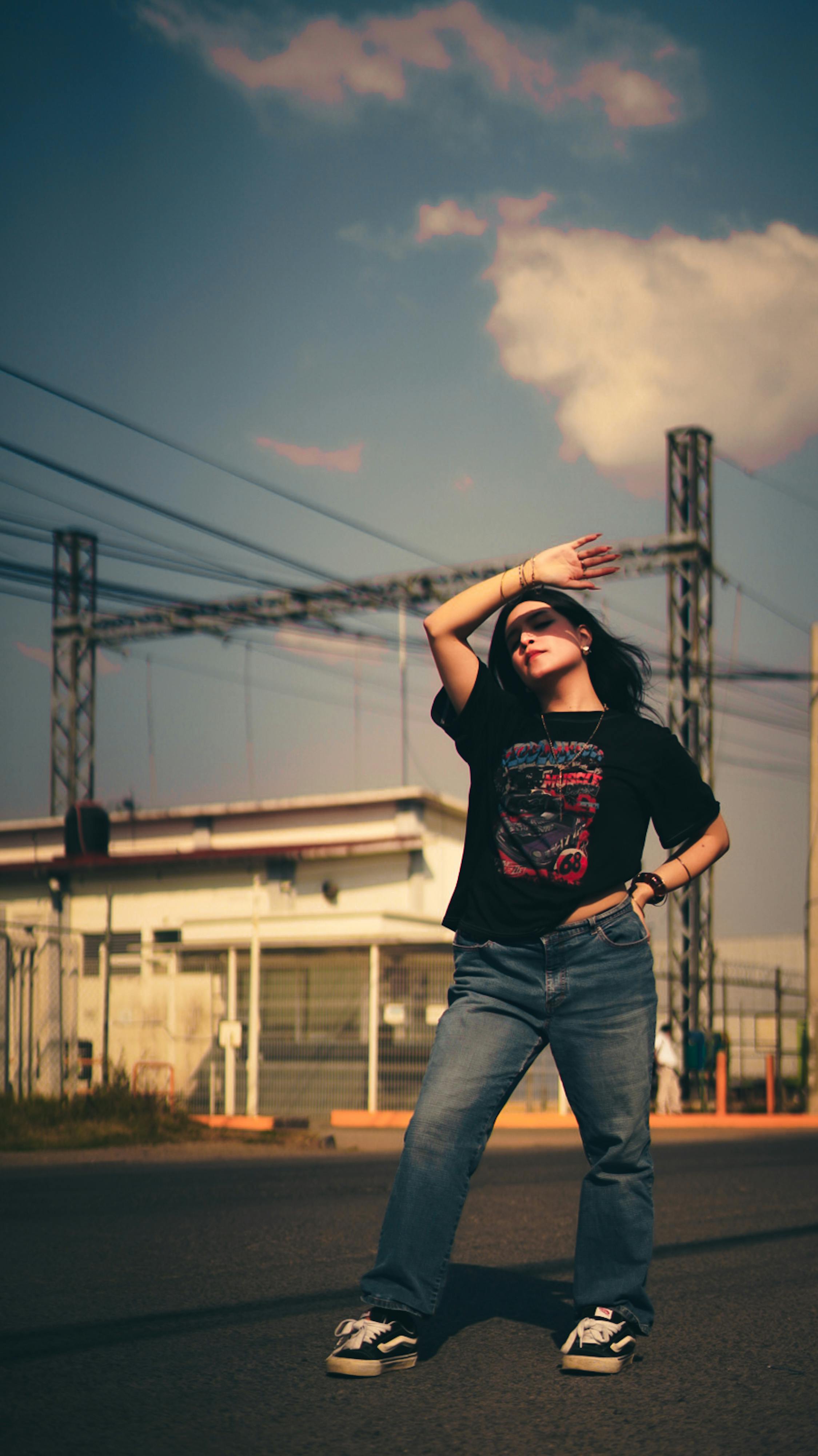 Free Stylish young woman poses confidently outdoors on a sunny day, showcasing casual fashion. Stock Photo