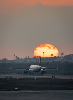 Captured moment of a plane landing at LAX with the sun setting dramatically in the background.