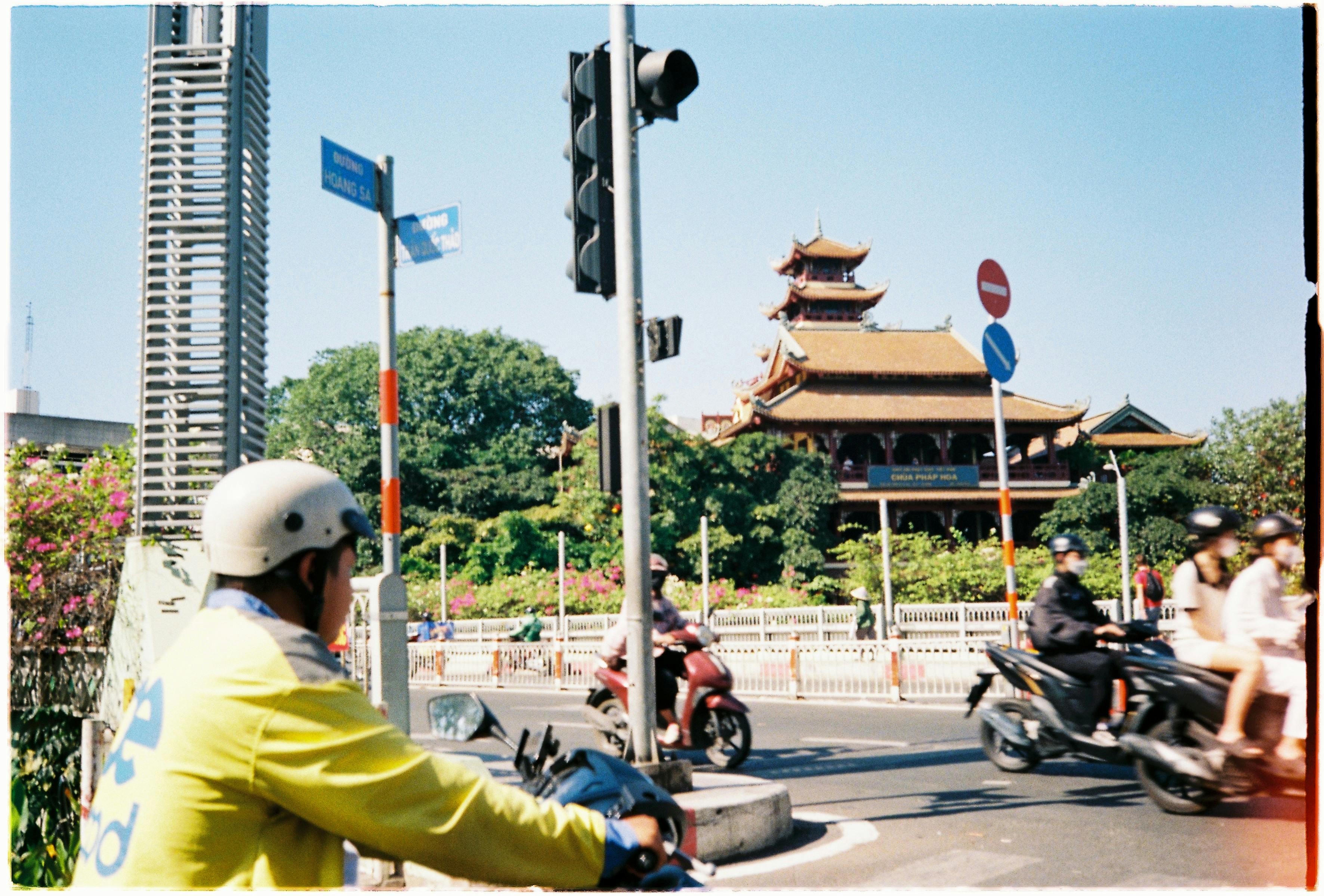 Street view in Ho Chi Minh City with bustling traffic and traditional architecture.