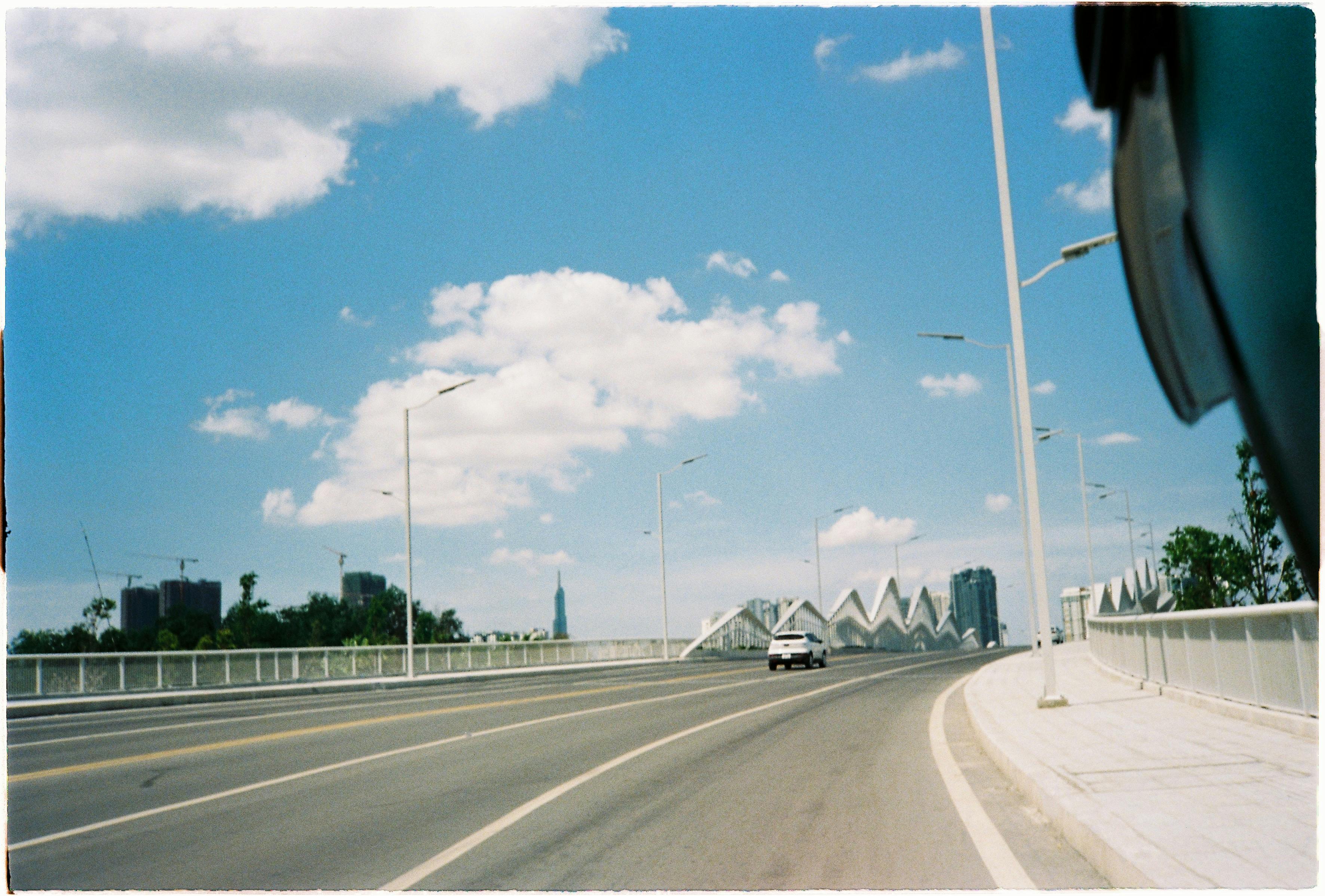 Gratuit Vedere a unui pod și a reperului 81 din orașul Ho Chi Minh, Vietnam, sub un cer albastru strălucitor. Fotografie de stoc