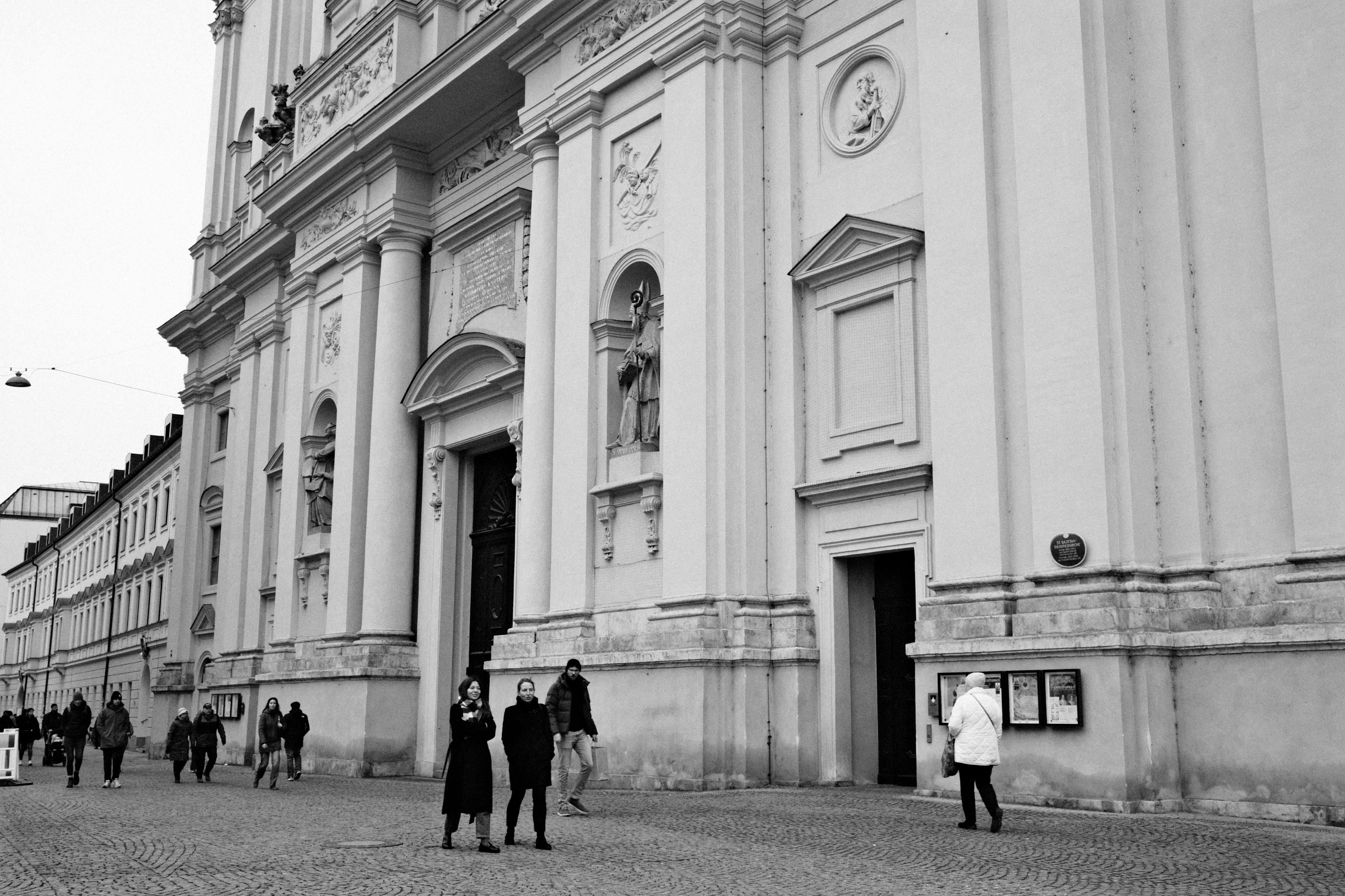 Gratis Sort-hvidt foto af historisk arkitektur med mennesker, der går på en gade i München. Lagerfoto