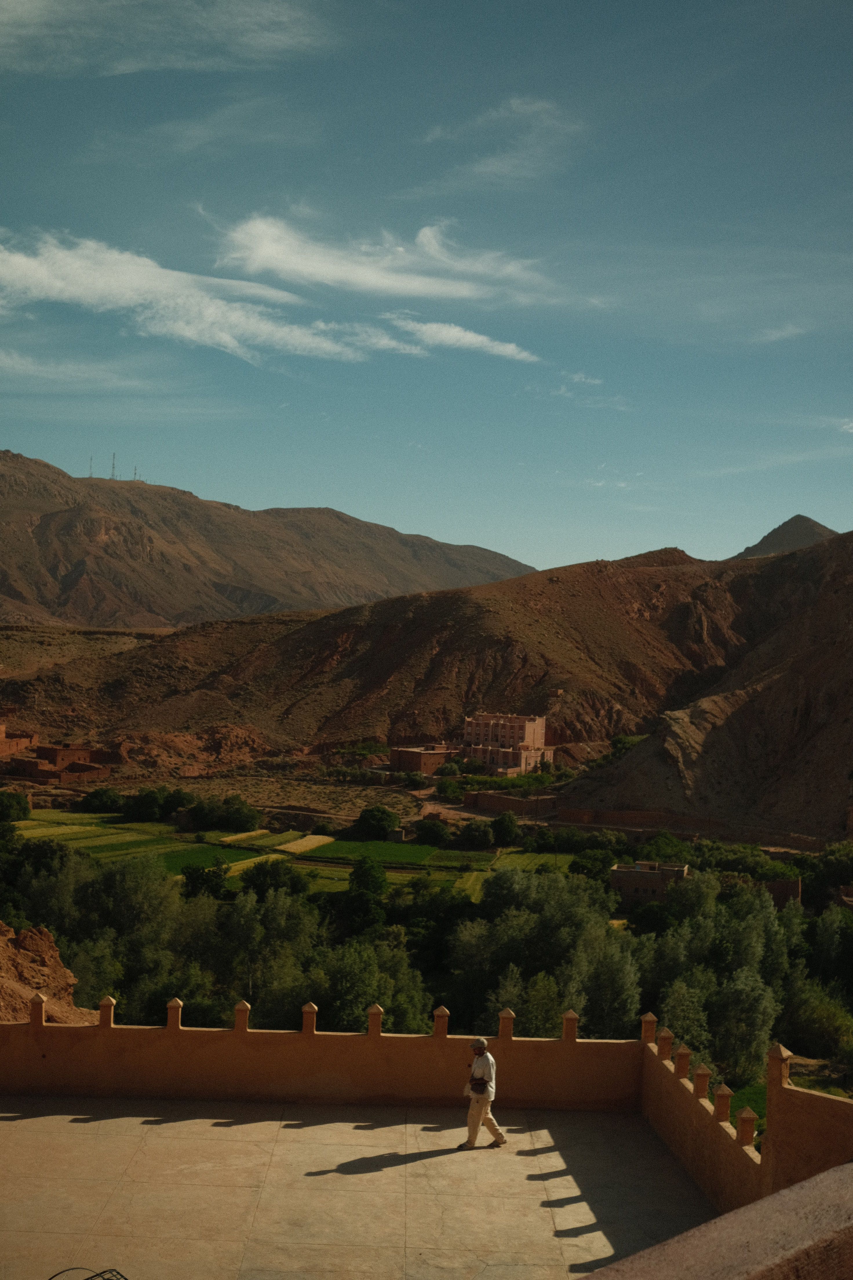 Breathtaking view of Morocco's Atlas Mountains with traditional architecture under natural light.