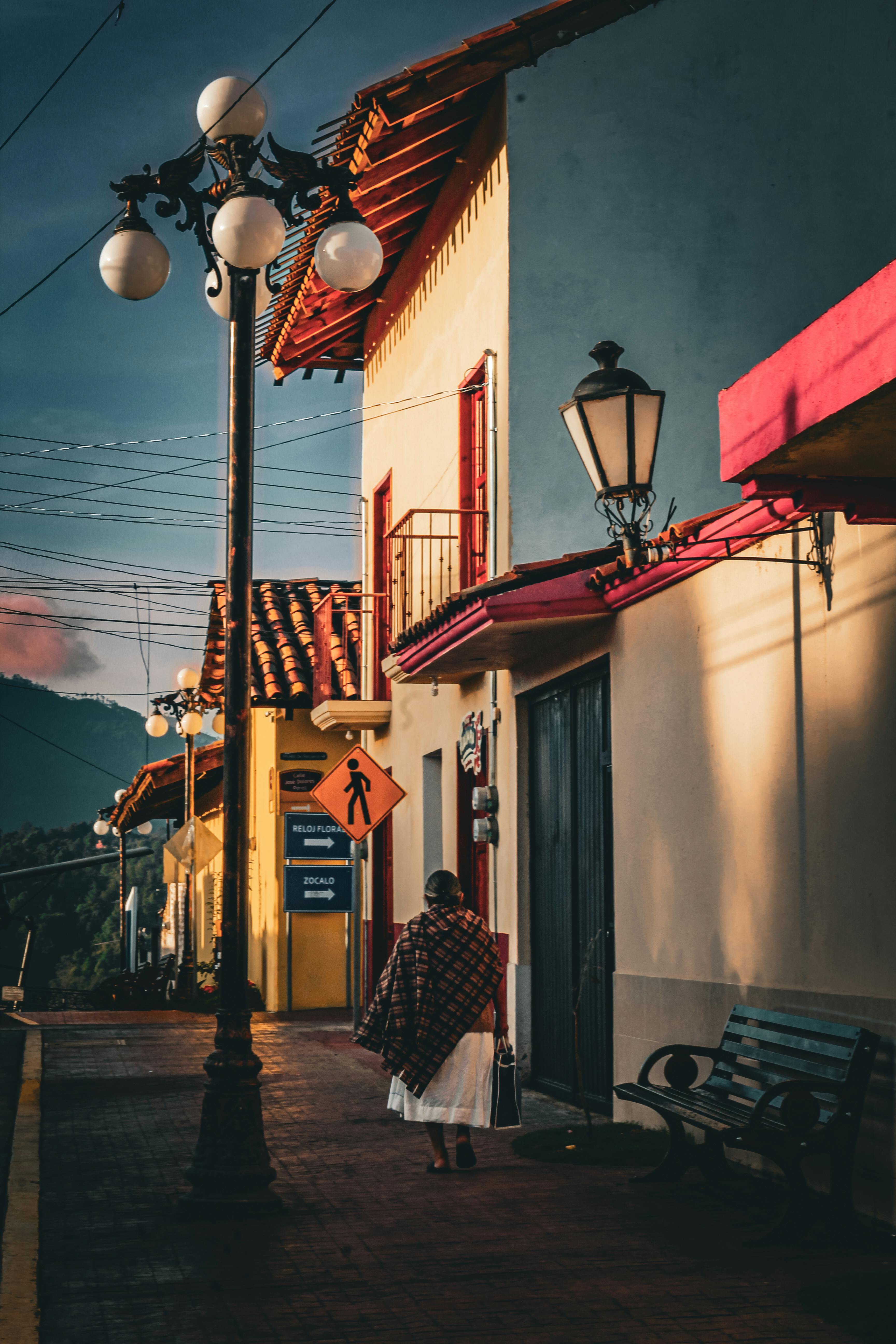 Bezpłatne Spokojny widok ulicy w meksykańskim miasteczku o zachodzie słońca, tradycyjna architektura i ciepłe oświetlenie. Zdjęcie z galerii