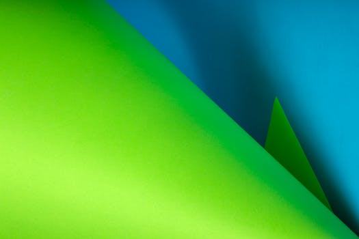 Dynamic abstract composition featuring layered green and blue paper. Ideal for creative backgrounds.
