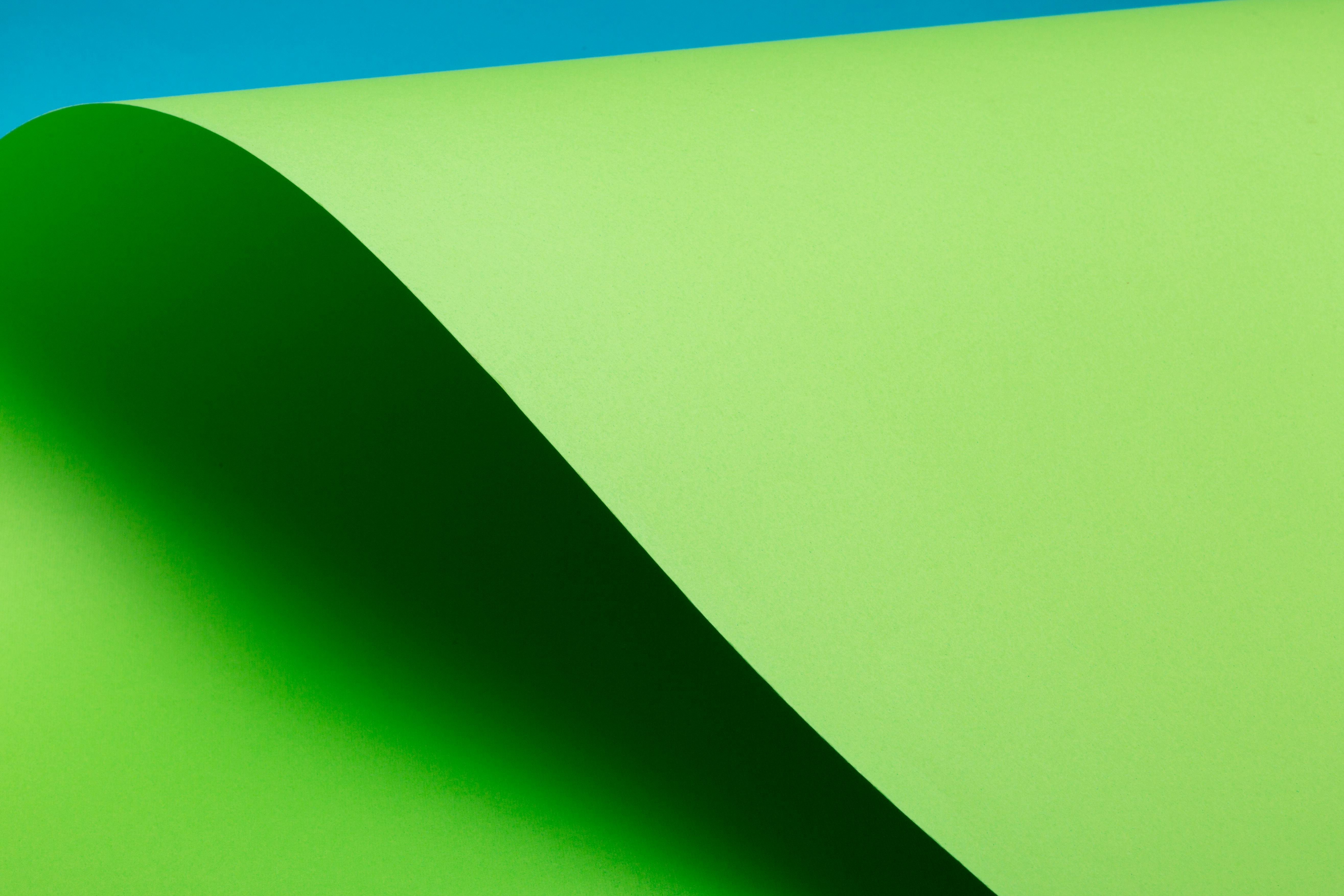 Free A minimalist abstract image with a green curve and blue background, perfect for creative design projects. Stock Photo