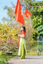 Woman in Traditional Dress with National Flags Outdoors