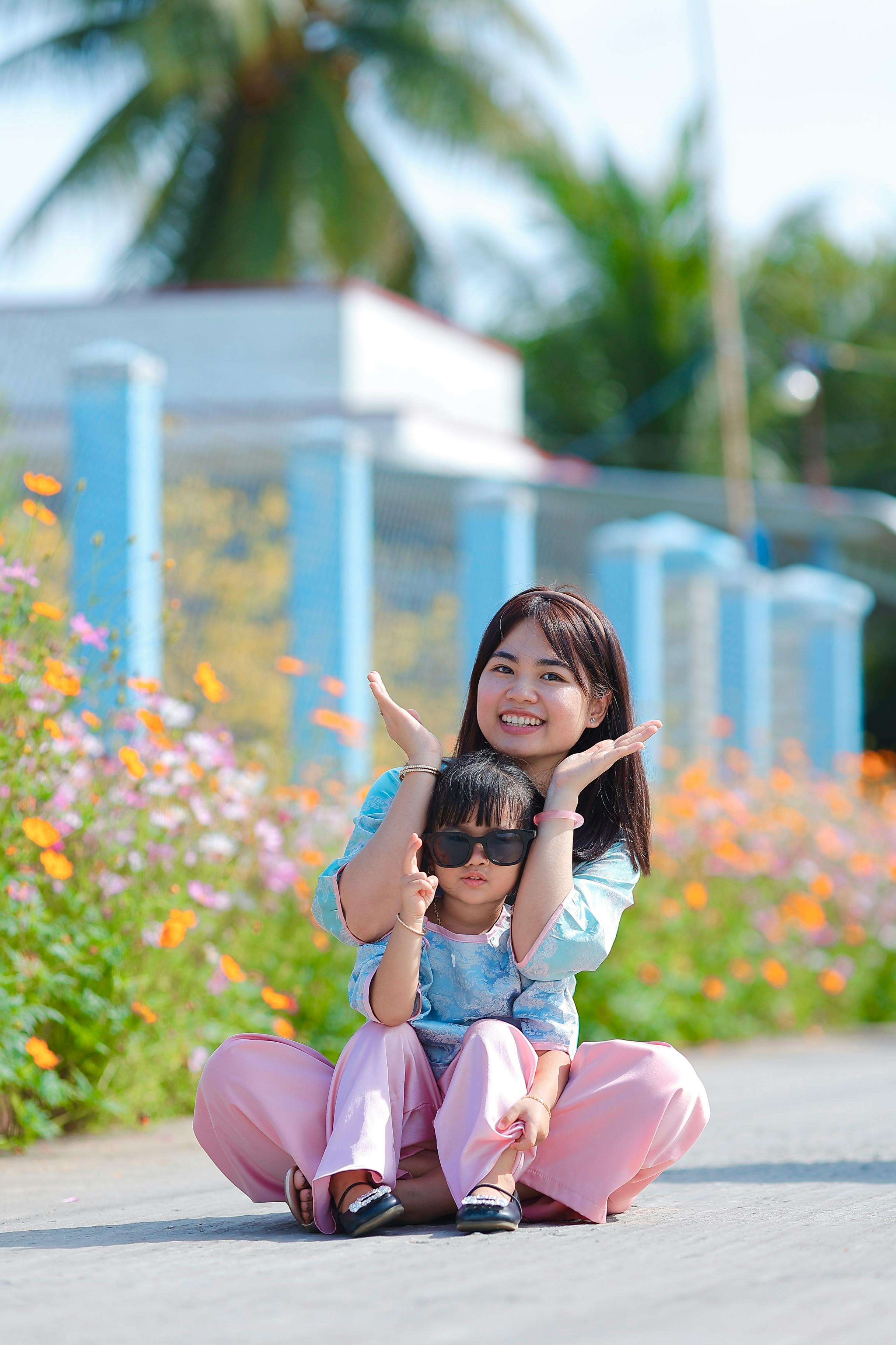Bezpłatne Matka z dzieckiem cieszą się słonecznym dniem na świeżym powietrzu, w otoczeniu kolorowych kwiatów. Zdjęcie z galerii