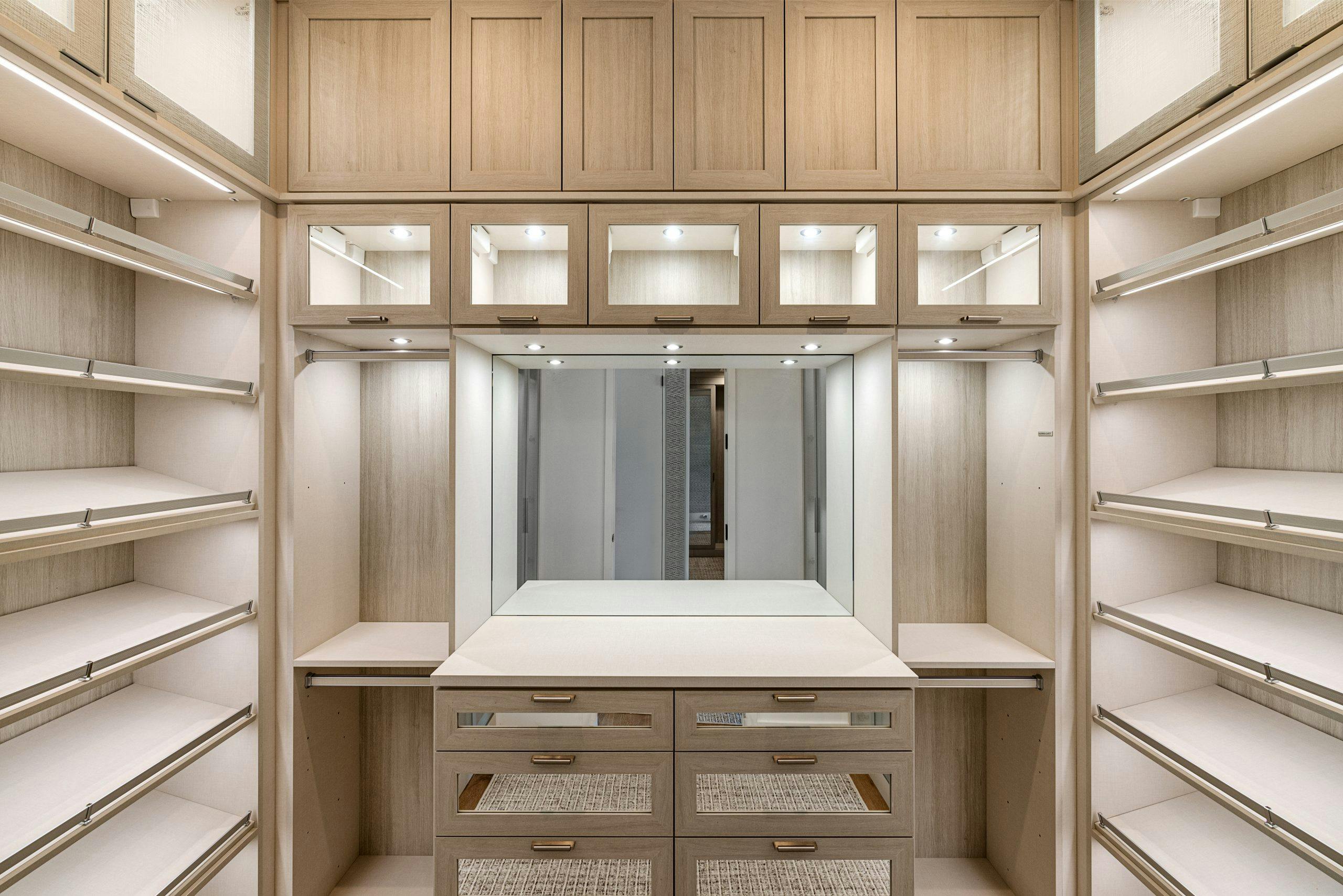 Spacious walk-in closet with wooden cabinets and ample lighting.