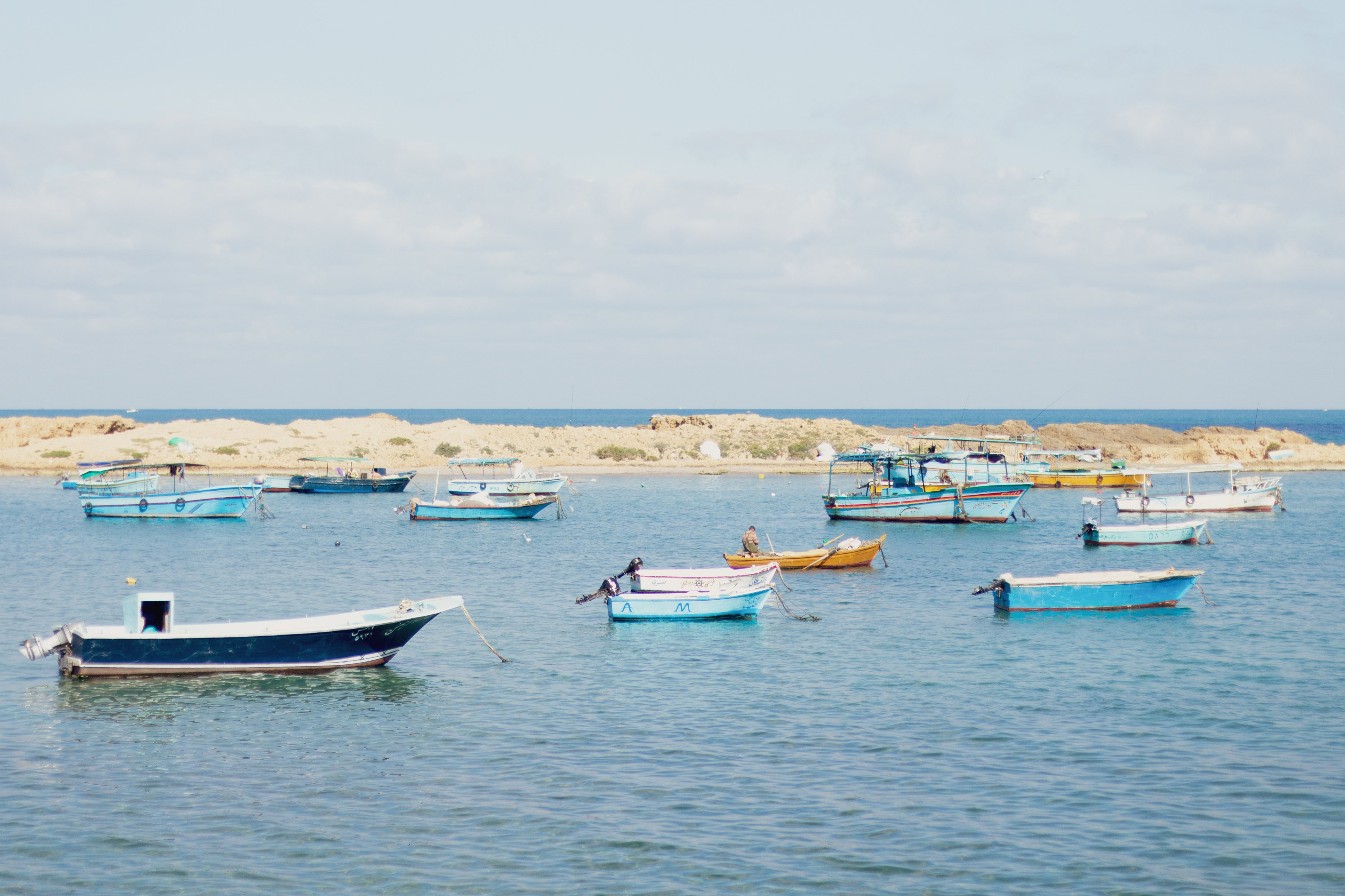 Gratis Escena serena de barcos pesqueros anclados en aguas tranquilas frente a la costa de Alejandría bajo un brillante cielo de verano. Foto de stock