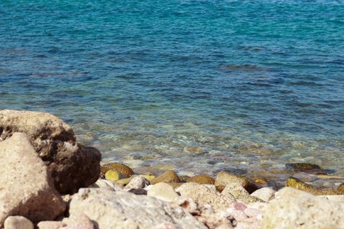 Free Rocky beach with clear blue water in Alexandria, Egypt, showcasing natural beauty and summer vibes. Stock Photo