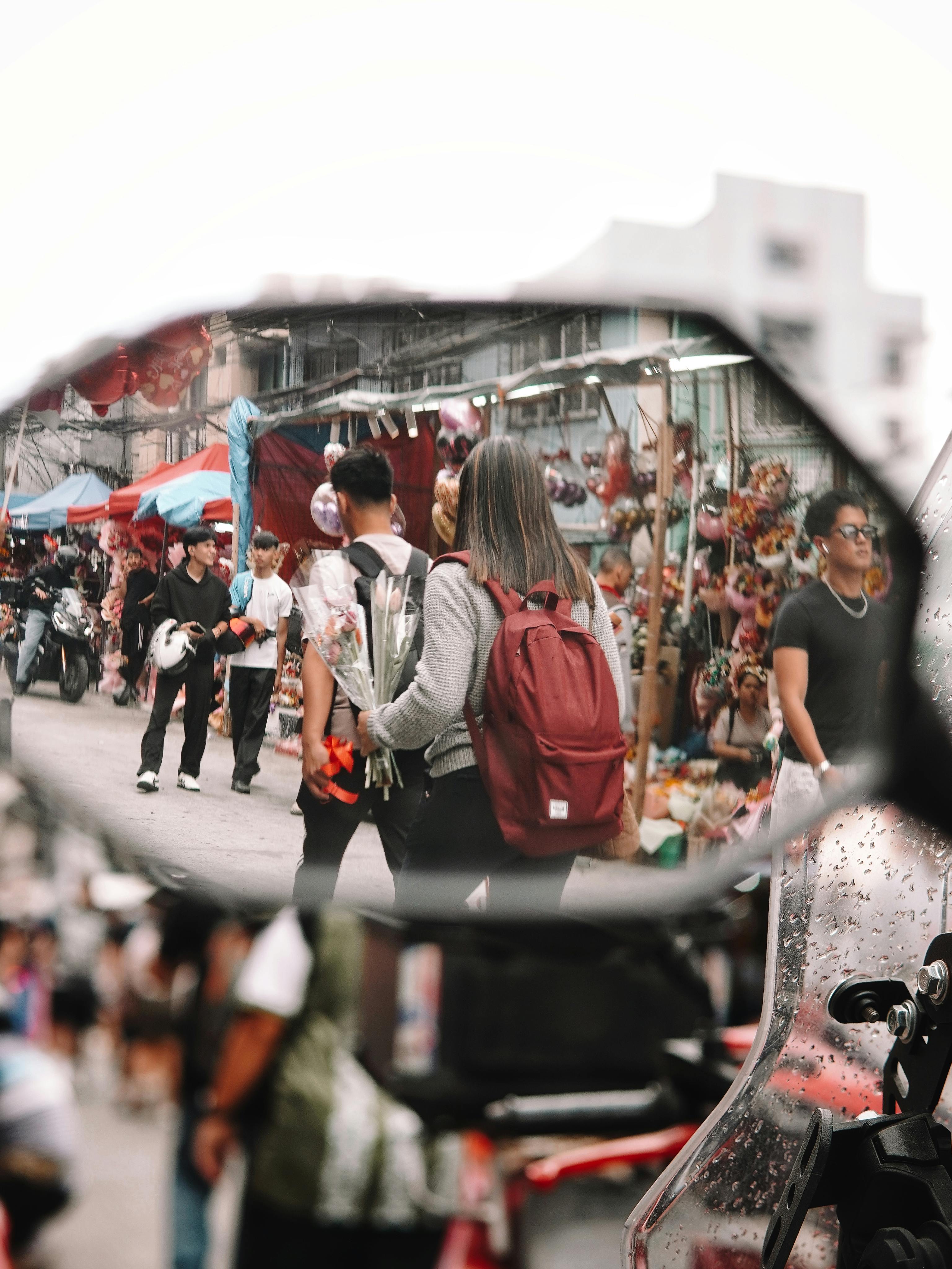 Gratis Scena di un mercato di strada affollato riflessa nello specchietto retrovisore di una motocicletta, che cattura la vivace vita cittadina. Foto a disposizione