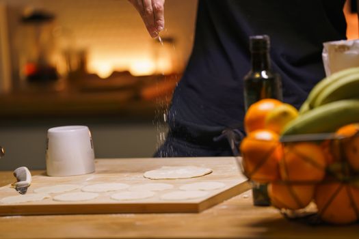 Warm and inviting kitchen setup with flour-dusted hands preparing dough, surrounded by fresh fruit.
